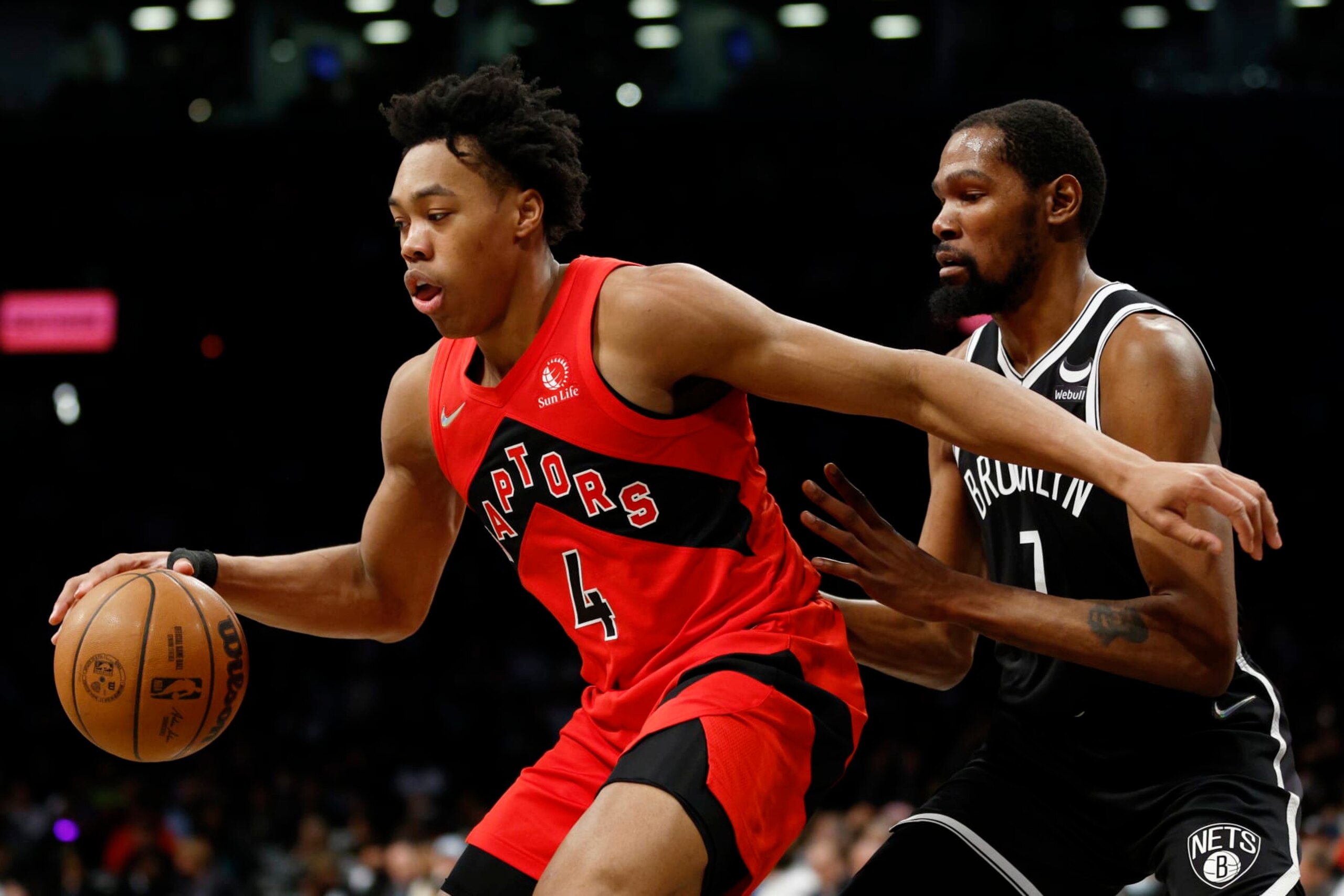 NEW YORK, NEW YORK - DECEMBER 14: Scottie Barnes #4 of the Toronto Raptors dribbles as Kevin Durant #7 of the Brooklyn Nets defends during the second half at Barclays Center on December 14, 2021 in the Brooklyn borough of New York City. The Nets won 131-129. NOTE TO USER: User expressly acknowledges and agrees that, by downloading and or using this photograph, User is consenting to the terms and conditions of the Getty Images License Agreement. (Photo by Sarah Stier/Getty Images)