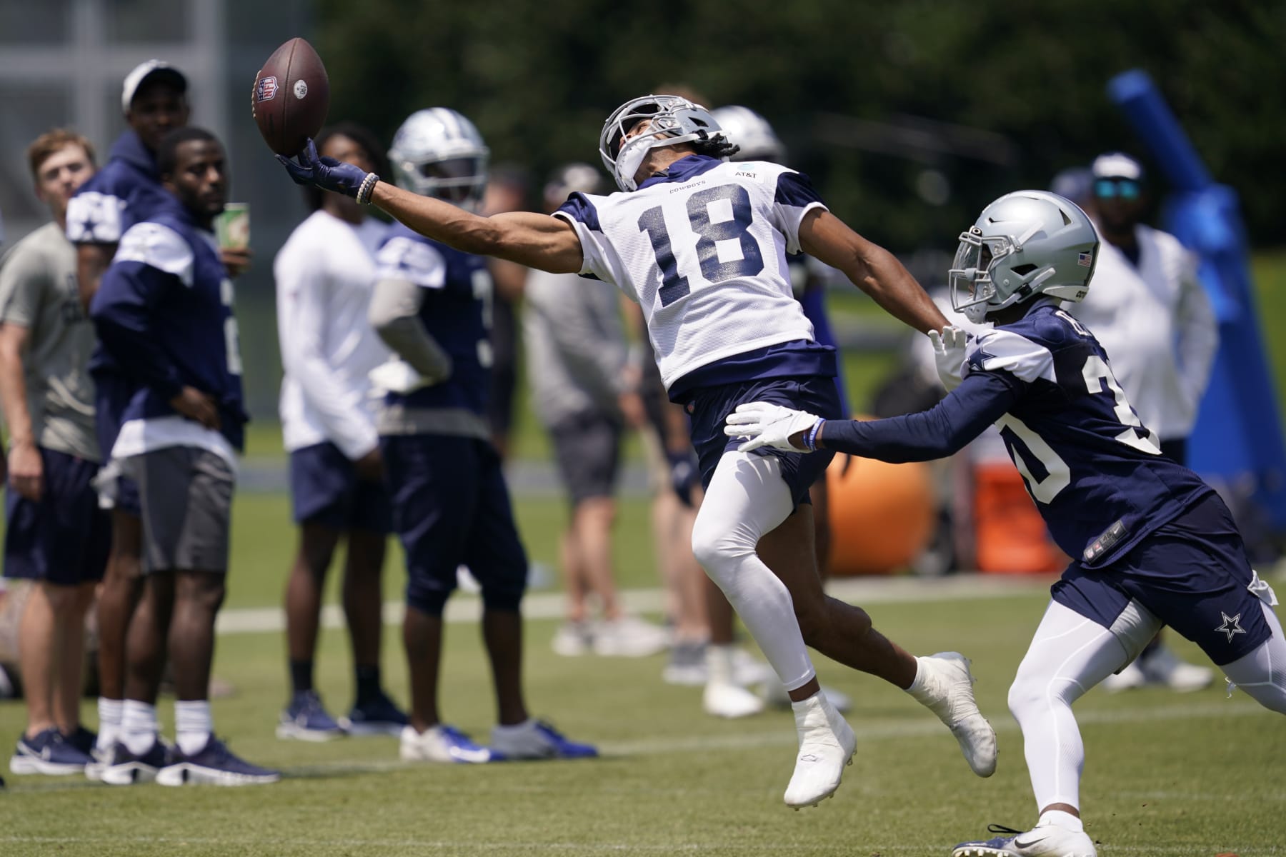 Dallas Cowboys wide receiver Jalen Tolbert (18) reaches out attempting to make a catch as cornerback DaRon Bland, right, defends, during a practice at the teams training facility, Thursday, June 9, 2022, in Frisco, Texas. (AP Photo/Tony Gutierrez)