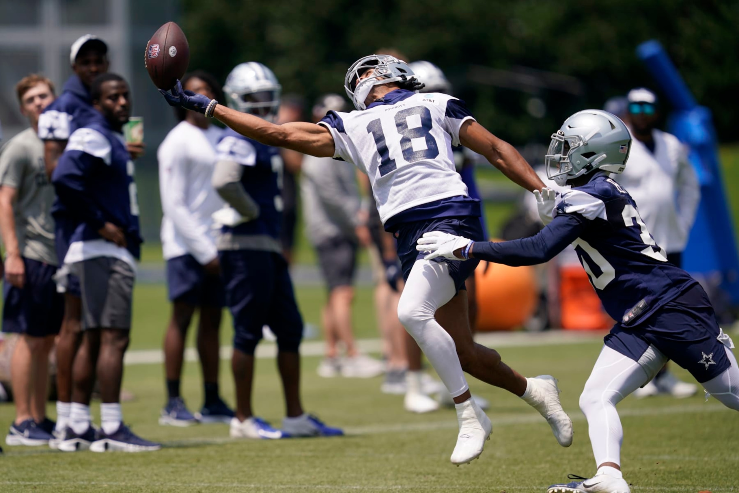 Dallas Cowboys wide receiver Jalen Tolbert (18) reaches out attempting to make a catch as cornerback DaRon Bland, right, defends, during a practice at the teams training facility, Thursday, June 9, 2022, in Frisco, Texas. (AP Photo/Tony Gutierrez)
