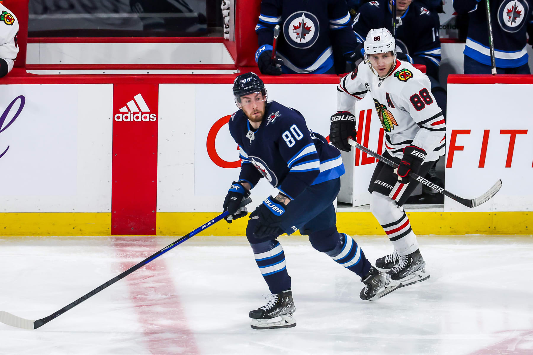 WINNIPEG, MB - FEBRUARY 14: Pierre-Luc Dubois #80 of the Winnipeg Jets and Patrick Kane #88 of the Chicago Blackhawks keep an eye on the play as they follow the play down the ice during second period action at the Canada Life Centre on February 14, 2022 in Winnipeg, Manitoba, Canada. (Photo by Jonathan Kozub/NHLI via Getty Images)