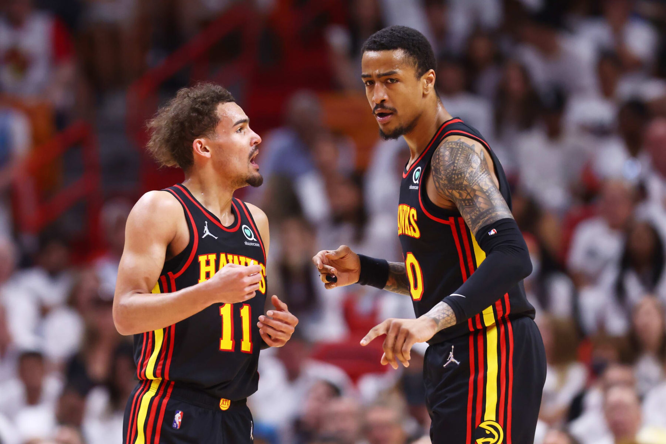 MIAMI, FLORIDA - APRIL 17: Trae Young #11 and John Collins #20 of the Atlanta Hawks talk against the Miami Heat during the first quarter in Game One of the Eastern Conference First Round at FTX Arena on April 17, 2022 in Miami, Florida. NOTE TO USER: User expressly acknowledges and agrees that, by downloading and or using this photograph, User is consenting to the terms and conditions of the Getty Images License Agreement.  (Photo by Michael Reaves/Getty Images)