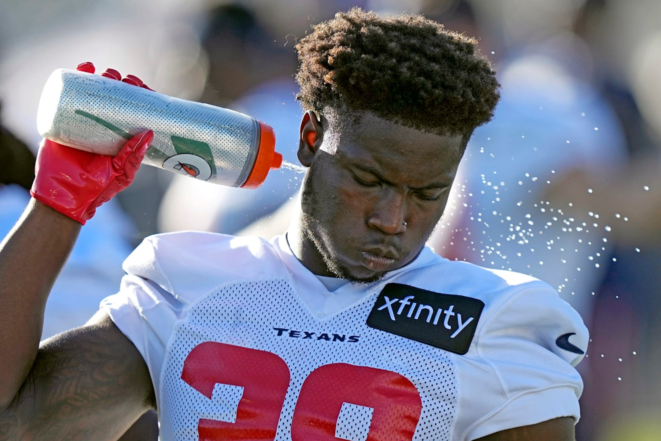 Houston Texans' Jacobi Francis sprays water on the back of his neck during an NFL football training camp practice Friday, July 29, 2022, in Houston. (AP Photo/David J. Phillip)