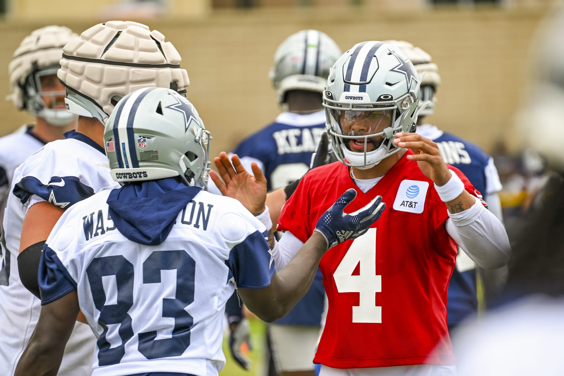 Dallas Cowboys quarterback Dak Prescott (4) celebrates a play with wide receiver James Washington (83) on opening day of NFL football training camp, Saturday, July 30, 2022, in Oxnard, Calif. (AP Photo/Gus Ruelas)