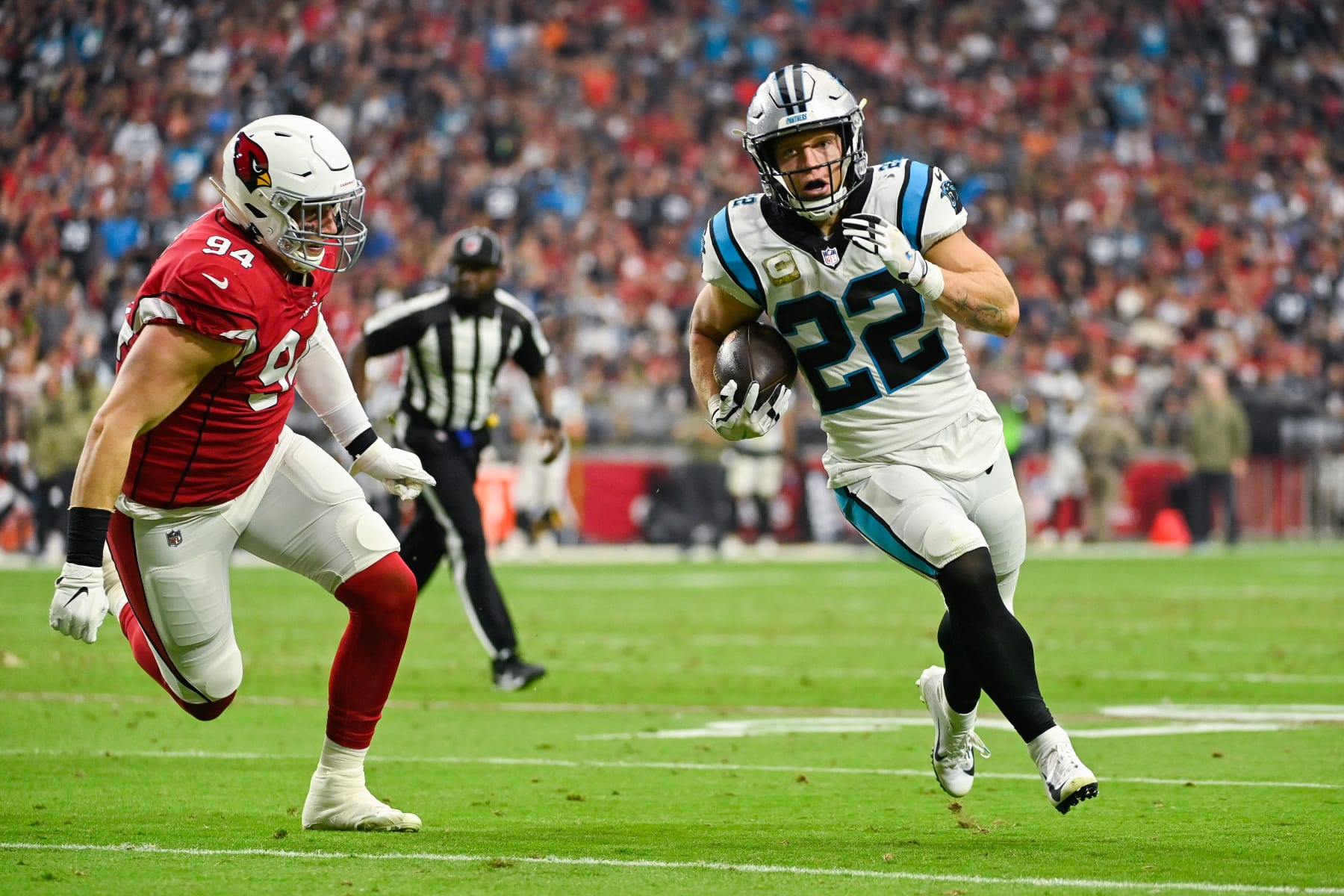 GLENDALE, ARIZONA - NOVEMBER 14: Christian McCaffrey #22 of the Carolina Panthers runs with the ball against Zach Allen #94 of the Arizona Cardinals during the first quarter at State Farm Stadium on November 14, 2021 in Glendale, Arizona. The Panthers defeated the Cardinals 34-10. (Photo by Kelsey Grant/Getty Images)