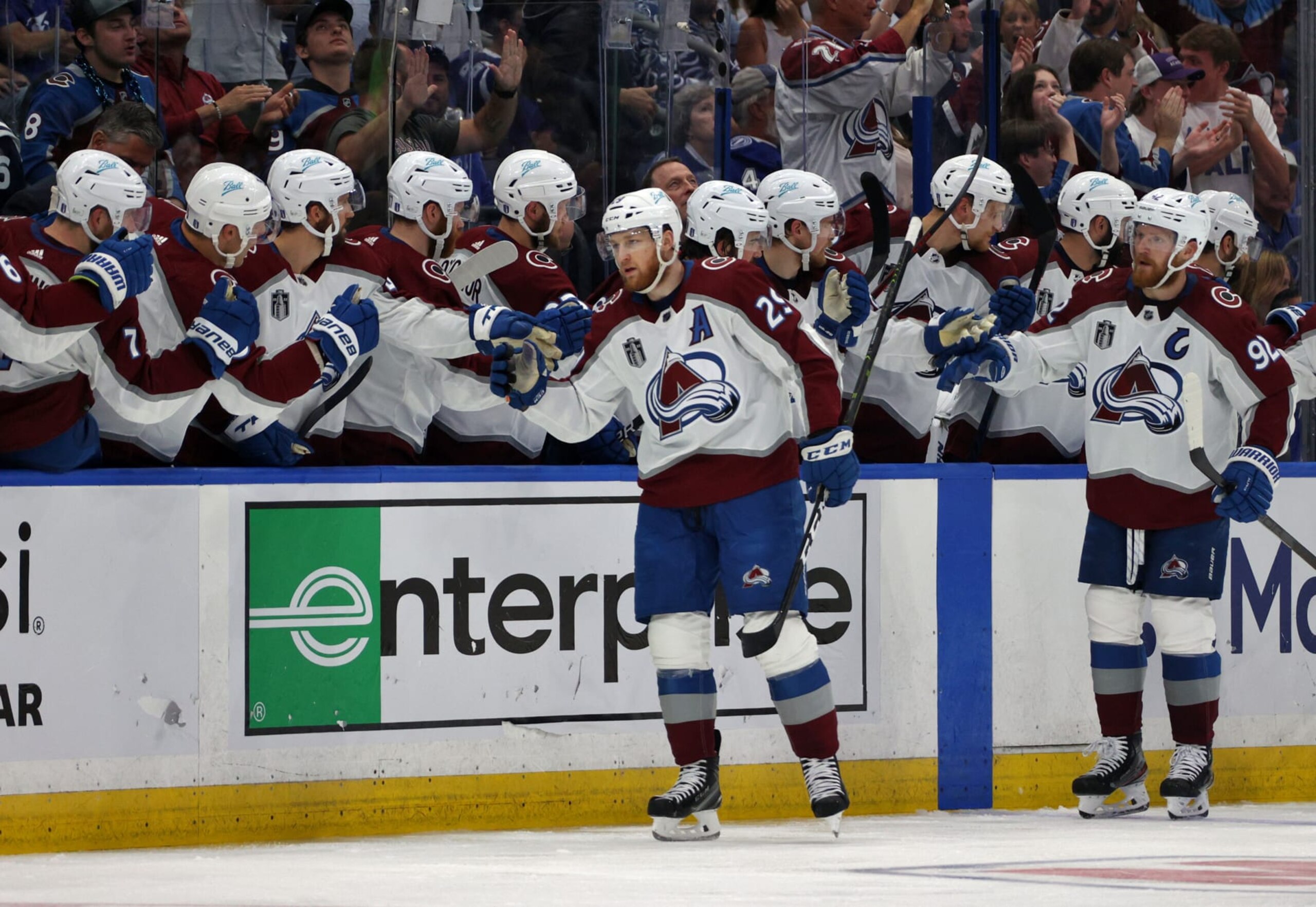 TAMPA, FLORIDA - JUNE 26: Nathan MacKinnon #29 and Gabriel Landeskog #92 of the Colorado Avalanche skate by the bench to celebrate with teammates after MacKinnon scored in the second period of Game Six of the 2022 Stanley Cup Final against the Tampa Bay Lightning at Amalie Arena on June 26, 2022 in Tampa, Florida. (Photo by Dave Sandford/NHLI via Getty Images) TAMPA, FLORIDA - JUNE 26: Nathan MacKinnon #29 and Gabriel Landeskog #92 of the Colorado Avalanche skate by the bench to celebrate with teammates after MacKinnon scored in the second period of Game Six of the 2022 Stanley Cup Final against the Tampa Bay Lightning at Amalie Arena on June 26, 2022 in Tampa, Florida. (Photo by Dave Sandford/NHLI via Getty Images)