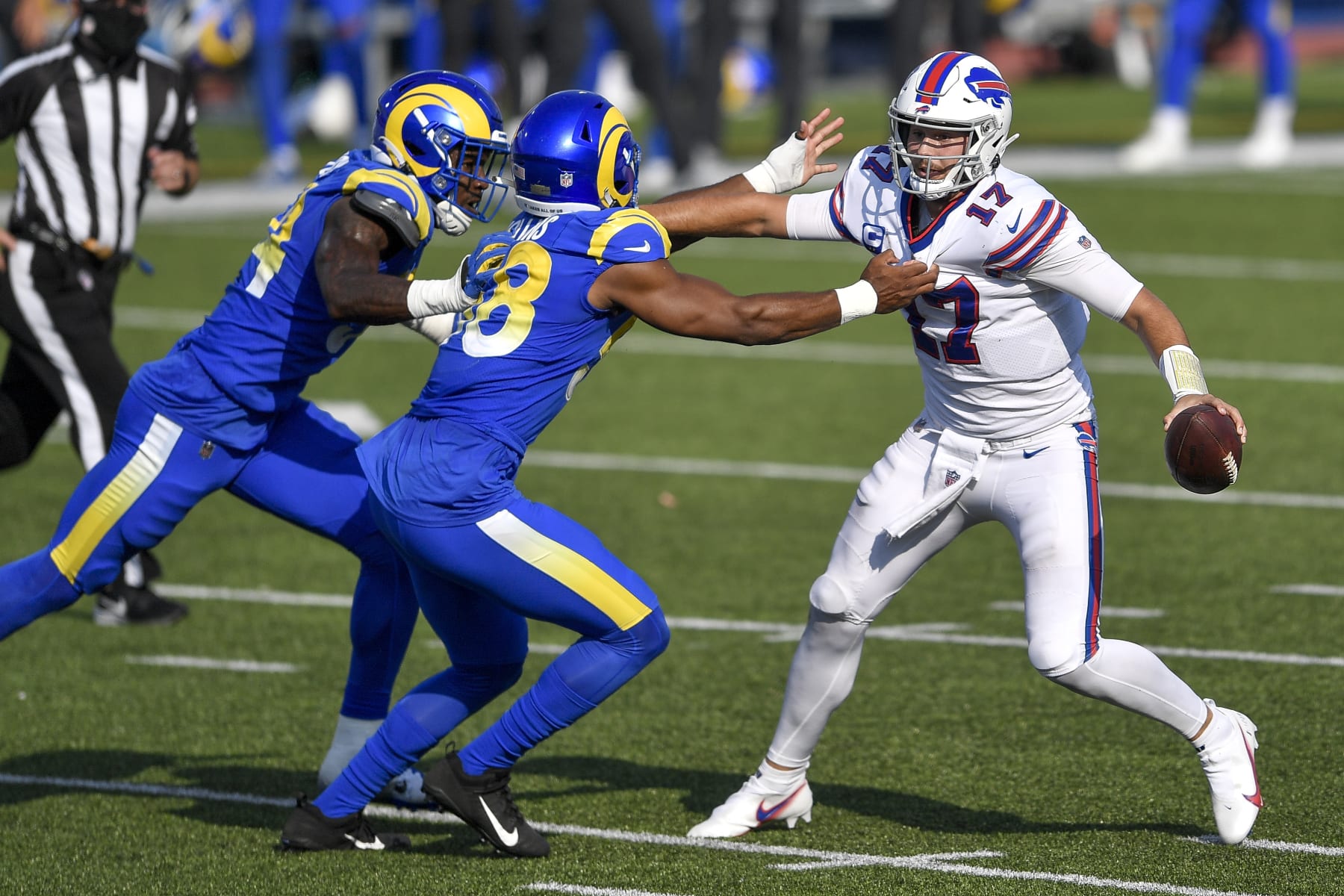 Buffalo Bills quarterback Josh Allen, right, tries to avoid pressure from Los Angeles Rams linebacker Justin Hollins, center, and linebacker Leonard Floyd, left, during the second half of an NFL football game Sunday, Sept. 27, 2020, in Orchard Park, N.Y. (AP Photo/Adrian Kraus)