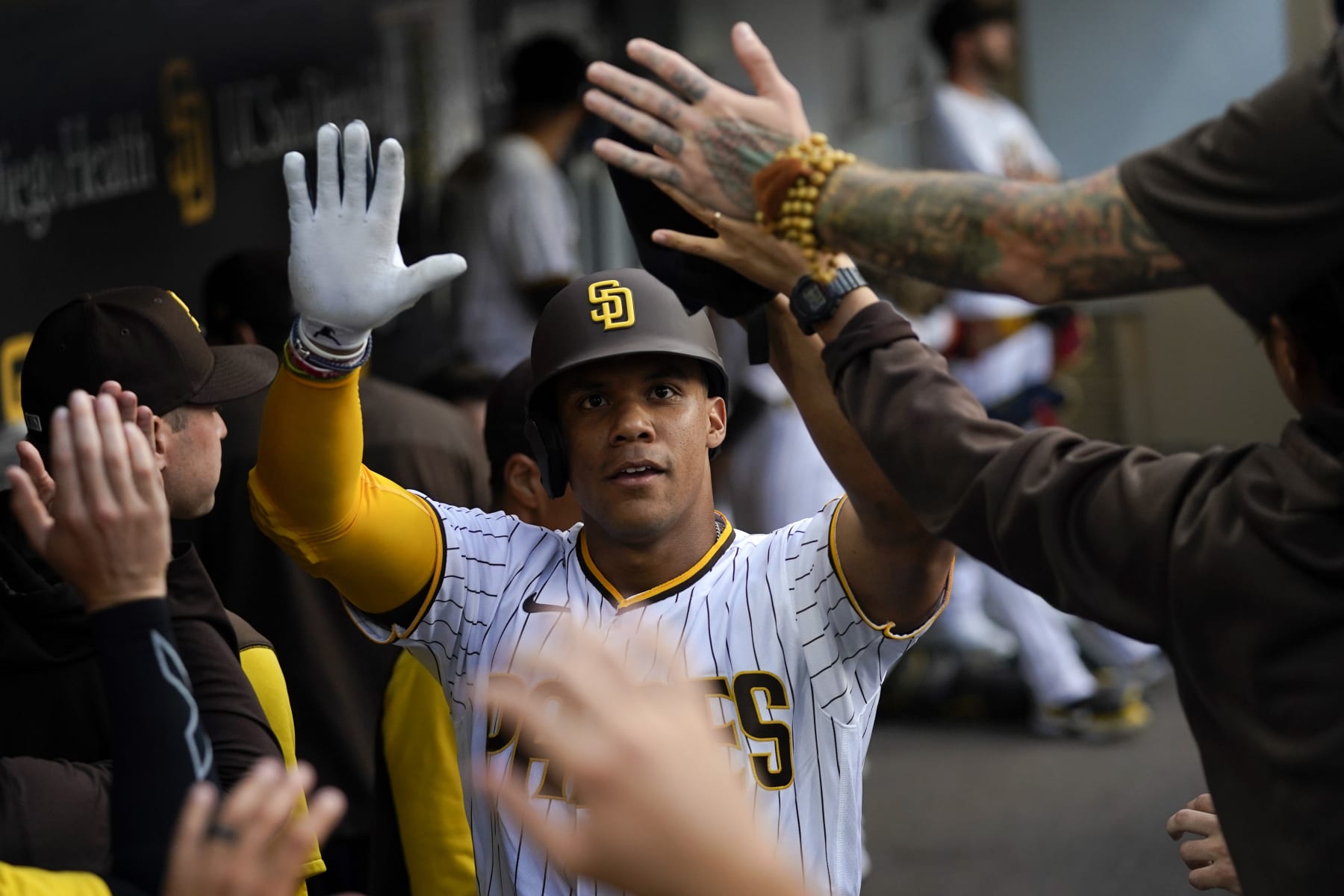 San Diego Padres' Juan Soto celebrates with teammates after scoring from third base when Jake Cronenworth was hit by a pitch during the first inning of the team's baseball game against the Colorado Rockies, Wednesday, Aug. 3, 2022, in San Diego. (AP Photo/Gregory Bull)
