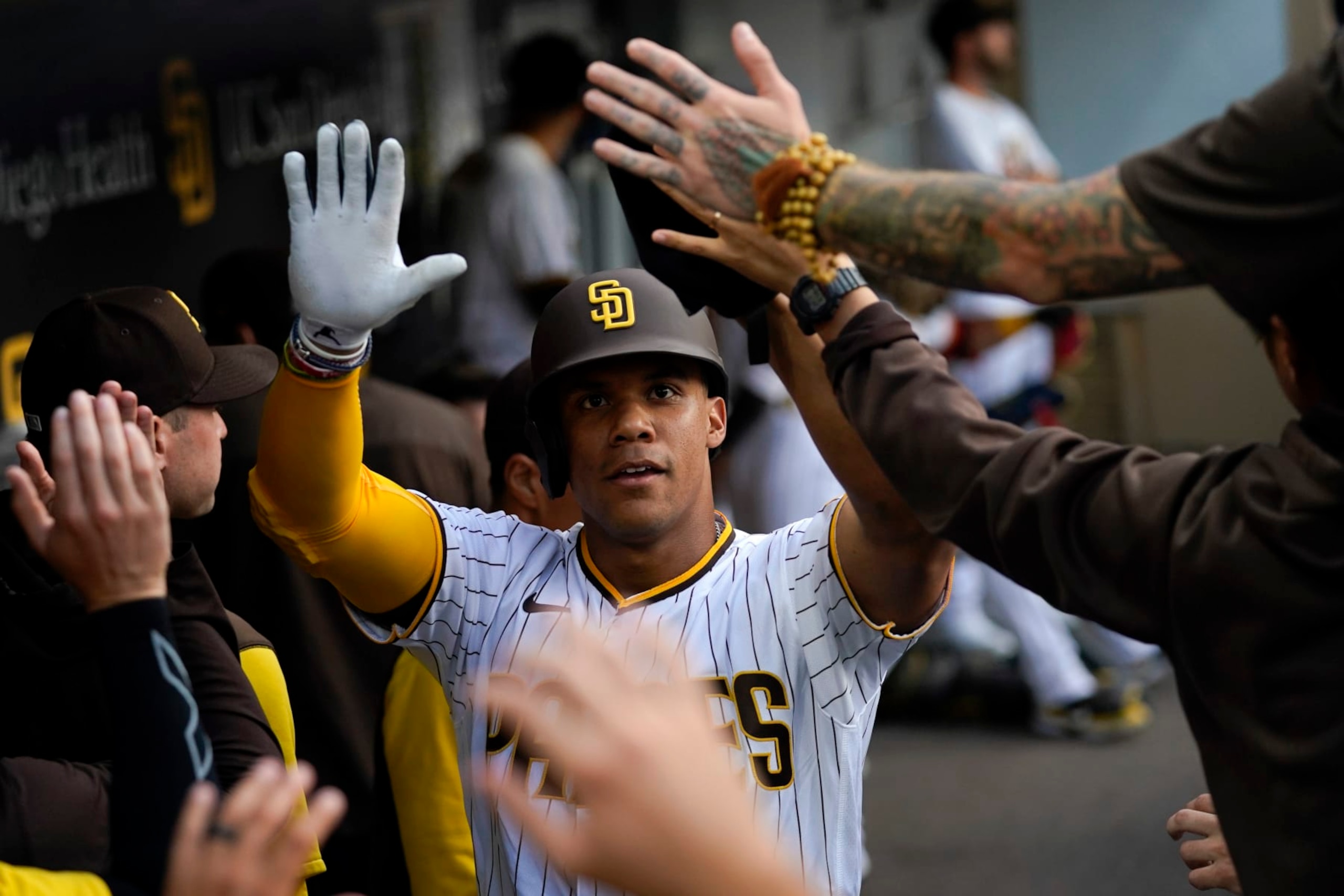 San Diego Padres' Juan Soto celebrates with teammates after scoring from third base when Jake Cronenworth was hit by a pitch during the first inning of the team's baseball game against the Colorado Rockies, Wednesday, Aug. 3, 2022, in San Diego. (AP Photo/Gregory Bull)