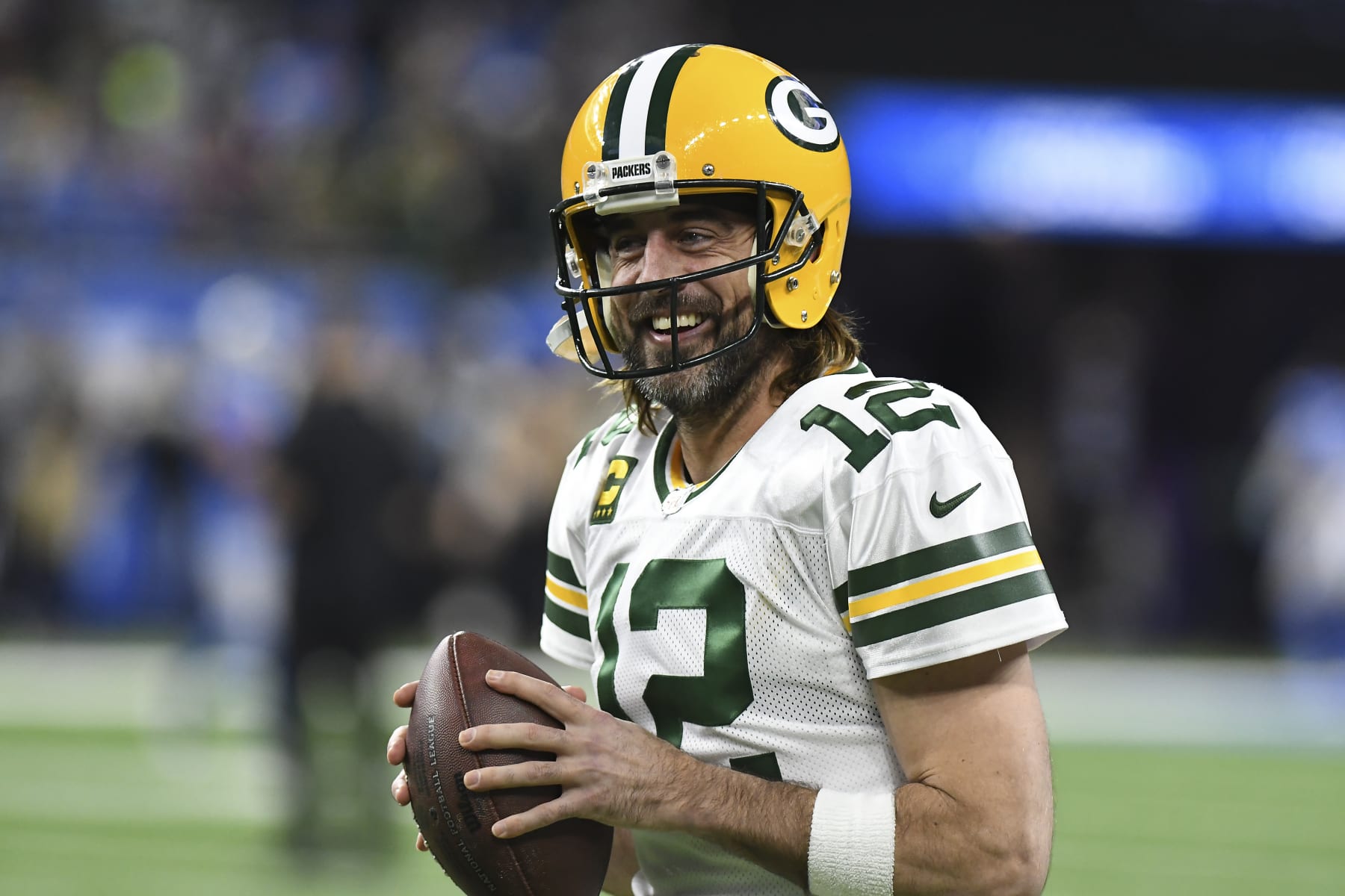 ARCHIVO - Aaron Rodgers, quarterback de los Packers de Green Bay, sonríe durante los ejercicios previos a un partido de la NFL en contra de los Lions de Detroit, el domingo 9 de enero de 2022, en Detroit. Aaron Rodgers planea regresar con Green Bay para su temporada 18 con el equipo. (AP Foto/Lon Horwedel, Archivo)