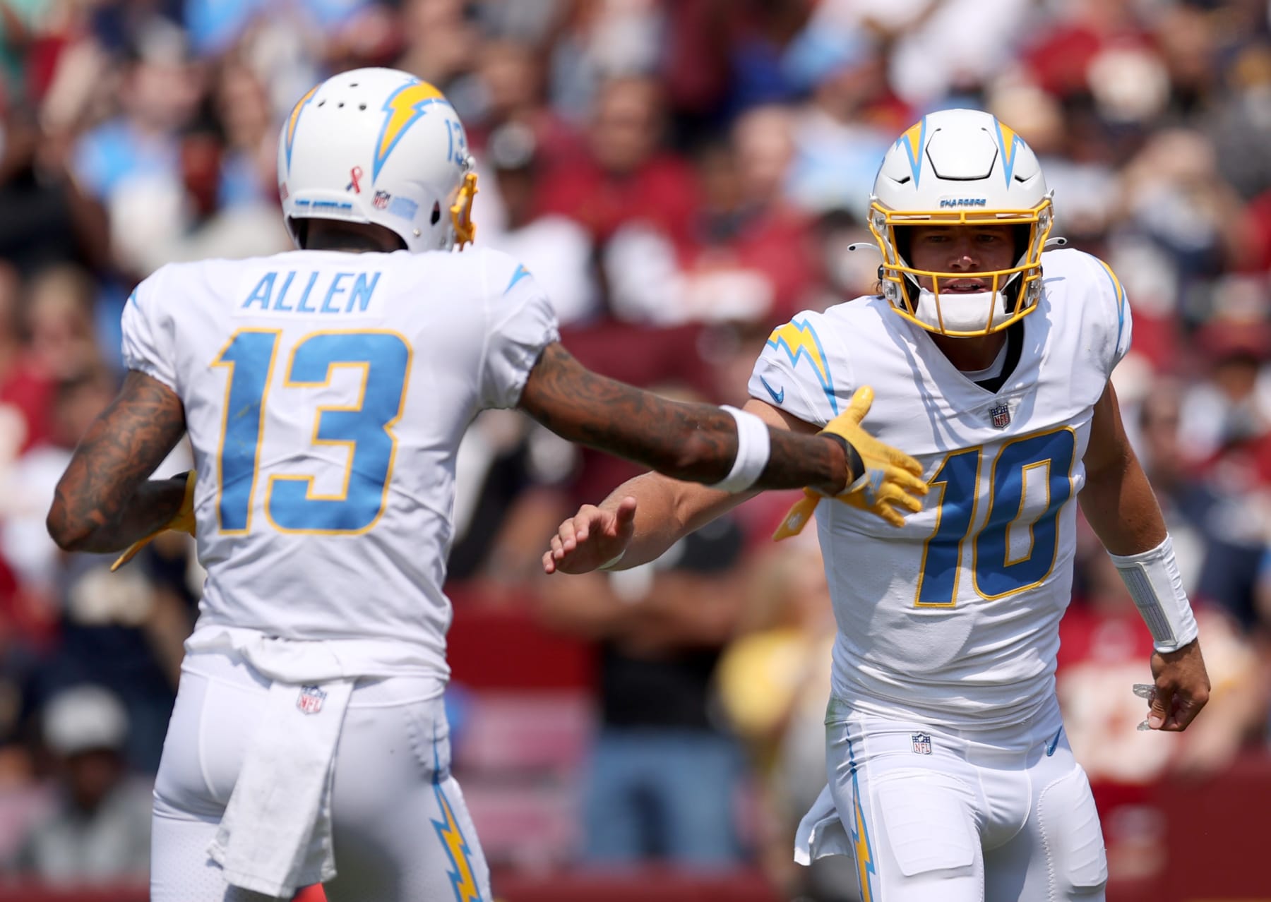 LANDOVER, MARYLAND - SEPTEMBER 12: Justin Herbert #10 and Keenan Allen #13 celebrate against the Washington Football Team during the first half at FedExField on September 12, 2021 in Landover, Maryland. (Photo by Patrick Smith/Getty Images)