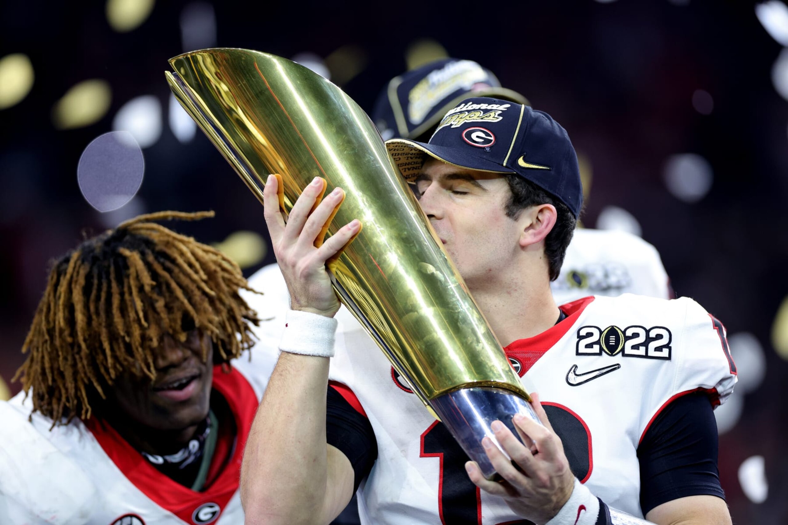 INDIANAPOLIS, INDIANA - JANUARY 10: Stetson Bennett #13 of the Georgia Bulldogs celebrates with the National Championship trophy after the Georgia Bulldogs defeated the Alabama Crimson Tide 33-18 during the 2022 CFP National Championship Game at Lucas Oil Stadium on January 10, 2022 in Indianapolis, Indiana. (Photo by Carmen Mandato/Getty Images) INDIANAPOLIS, INDIANA - JANUARY 10: Stetson Bennett #13 of the Georgia Bulldogs celebrates with the National Championship trophy after the Georgia Bulldogs defeated the Alabama Crimson Tide 33-18 during the 2022 CFP National Championship Game at Lucas Oil Stadium on January 10, 2022 in Indianapolis, Indiana. (Photo by Carmen Mandato/Getty Images)