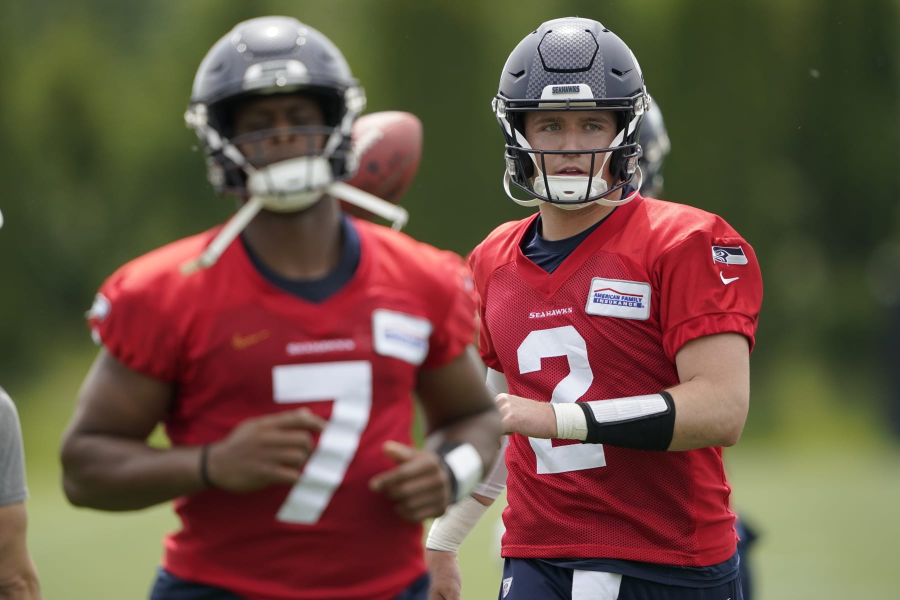 Seattle Seahawks quarterbacks Drew Lock (2) and Geno Smith (7) warm up before NFL football practice Tuesday, June 7, 2022, in Renton, Wash. (AP Photo/Ted S. Warren)
