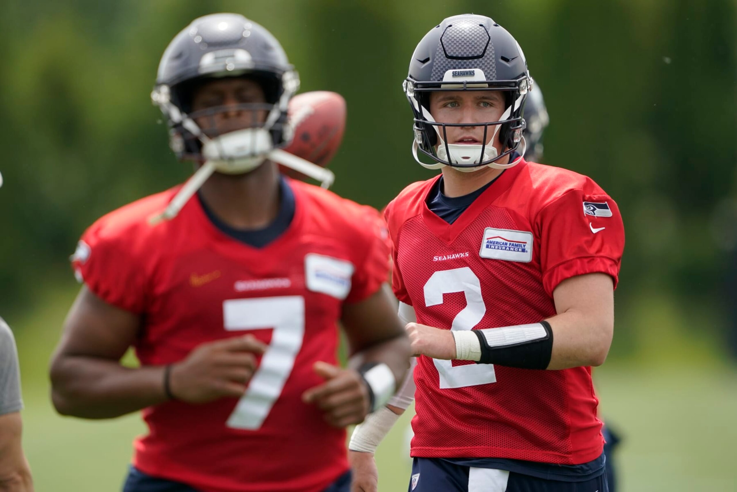 Seattle Seahawks quarterbacks Drew Lock (2) and Geno Smith (7) warm up before NFL football practice Tuesday, June 7, 2022, in Renton, Wash. (AP Photo/Ted S. Warren)