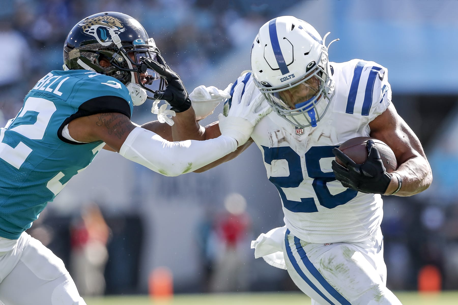 JACKSONVILLE, FL - JANUARY 9:  Running back Jonathan Taylor #28 of the Indianapolis Colts gives a stiff arm to corner back Tyson Campbell #32 of the Jacksonville Jaguars at TIAA Bank Field on January 9, 2022 in Jacksonville, Florida. The Jaguars won 26 -11. (Photo by Don Juan Moore/Getty Images)