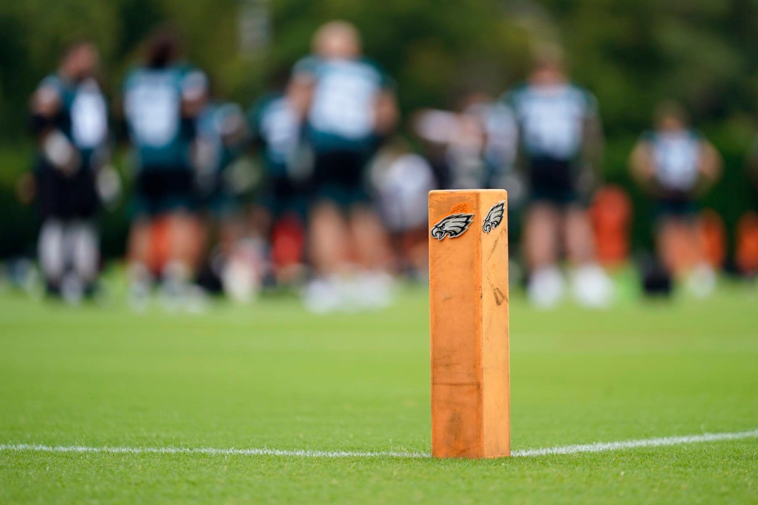 The Philadelphia Eagles' logo is seen as players warm up during training camp at the NFL football team's practice facility, Friday, July 29, 2022, in Philadelphia. (AP Photo/Matt Slocum)