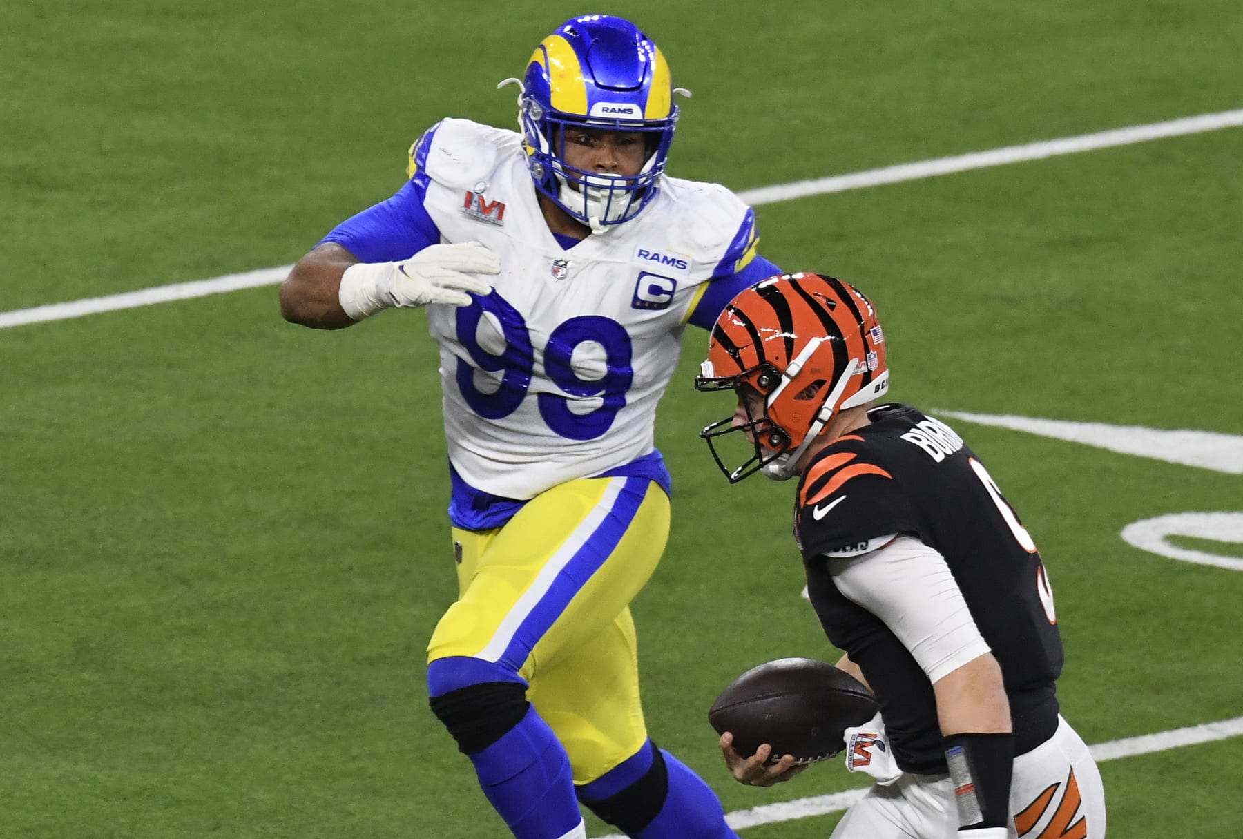 INGLEWOOD, CALIFORNIA - FEBRUARY 13: Joe Burrow #9 of the Cincinnati Bengals running with the ball is pursued by Aaron Donald #99 of the Los Angeles Rams during Super Bowl LVI at SoFi Stadium on February 13, 2022 in Inglewood, California. (Photo by Focus on Sport/Getty Images)