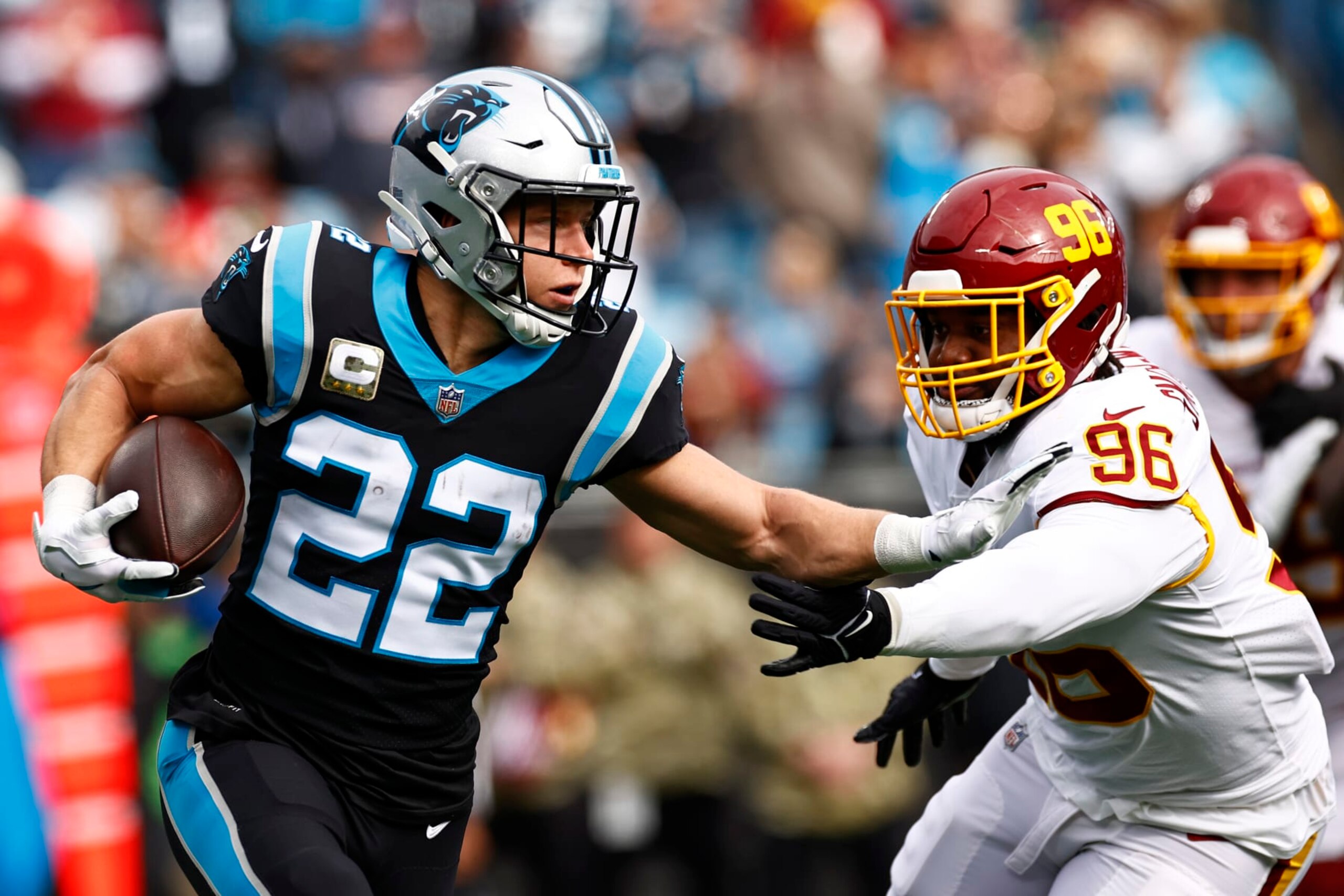 CHARLOTTE, NORTH CAROLINA - NOVEMBER 21: Christian McCaffrey #22 of the Carolina Panthers carries the ball against the defense of the Washington Football Team in the first quarter of the game at Bank of America Stadium on November 21, 2021 in Charlotte, North Carolina. (Photo by Jared C. Tilton/Getty Images)