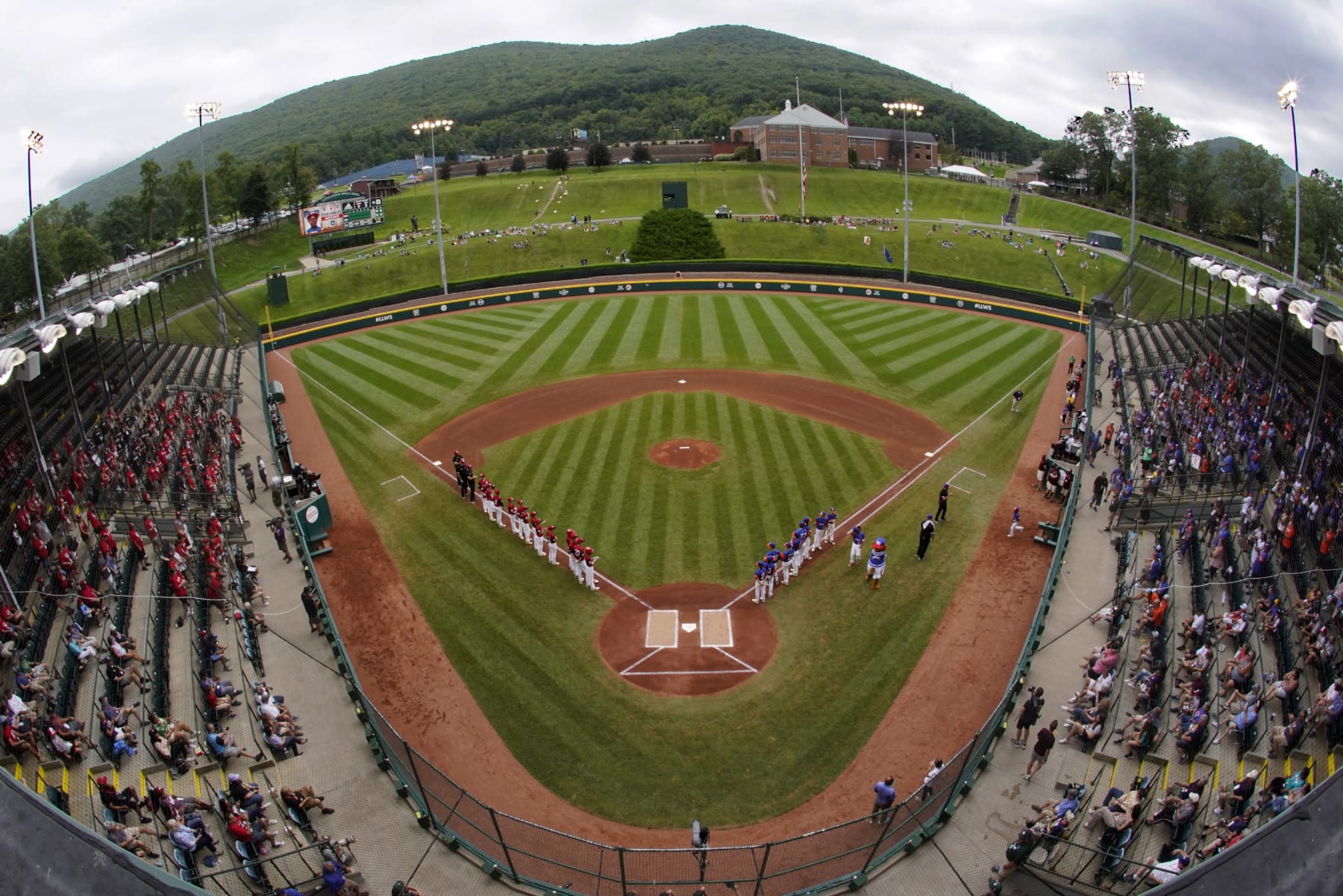 Hamilton, Ohio, lines the third base line and Taylor, Mich., line up on the first base line during player introductions before the Little League World Series Championship baseball game at Lamade Stadium in South Williamsport, Pa., Sunday, Aug. 29, 2021. (AP Photo/Gene J. Puskar)