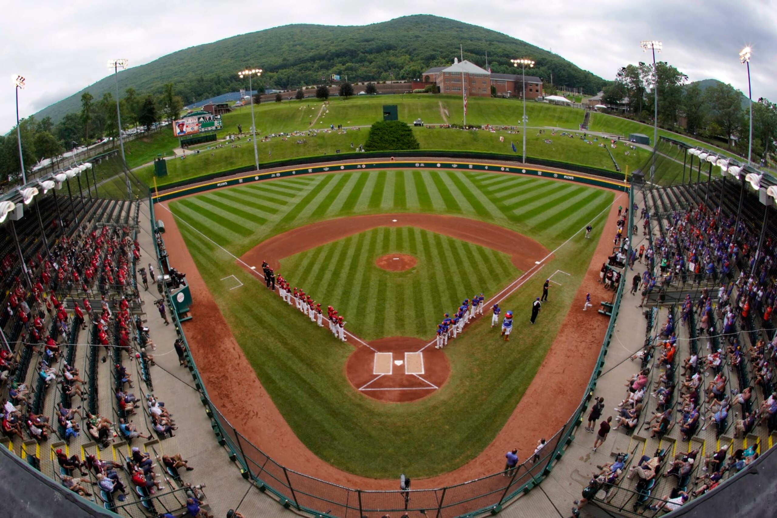 Hamilton, Ohio, lines the third base line and Taylor, Mich., line up on the first base line during player introductions before the Little League World Series Championship baseball game at Lamade Stadium in South Williamsport, Pa., Sunday, Aug. 29, 2021. (AP Photo/Gene J. Puskar)