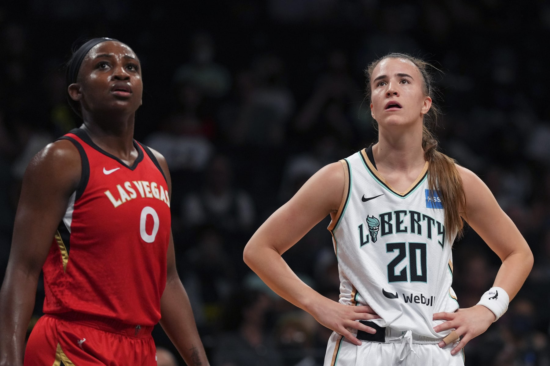 NEW YORK, NY - JULY 12: Jackie Young #0 of the Las Vegas Aces looks on along with Sabrina Ionescu #20 of the New York Liberty at Barclays Center on July 12, 2022 in the Brooklyn borough of New York City. The Las Vegas Aces defeated the New York Liberty 107-101. NOTE TO USER: User expressly acknowledges and agrees that, by downloading and/or using this Photograph, user is consenting to the terms and conditions of the Getty Images License Agreement. (Photo by Mitchell Leff/Getty Images)