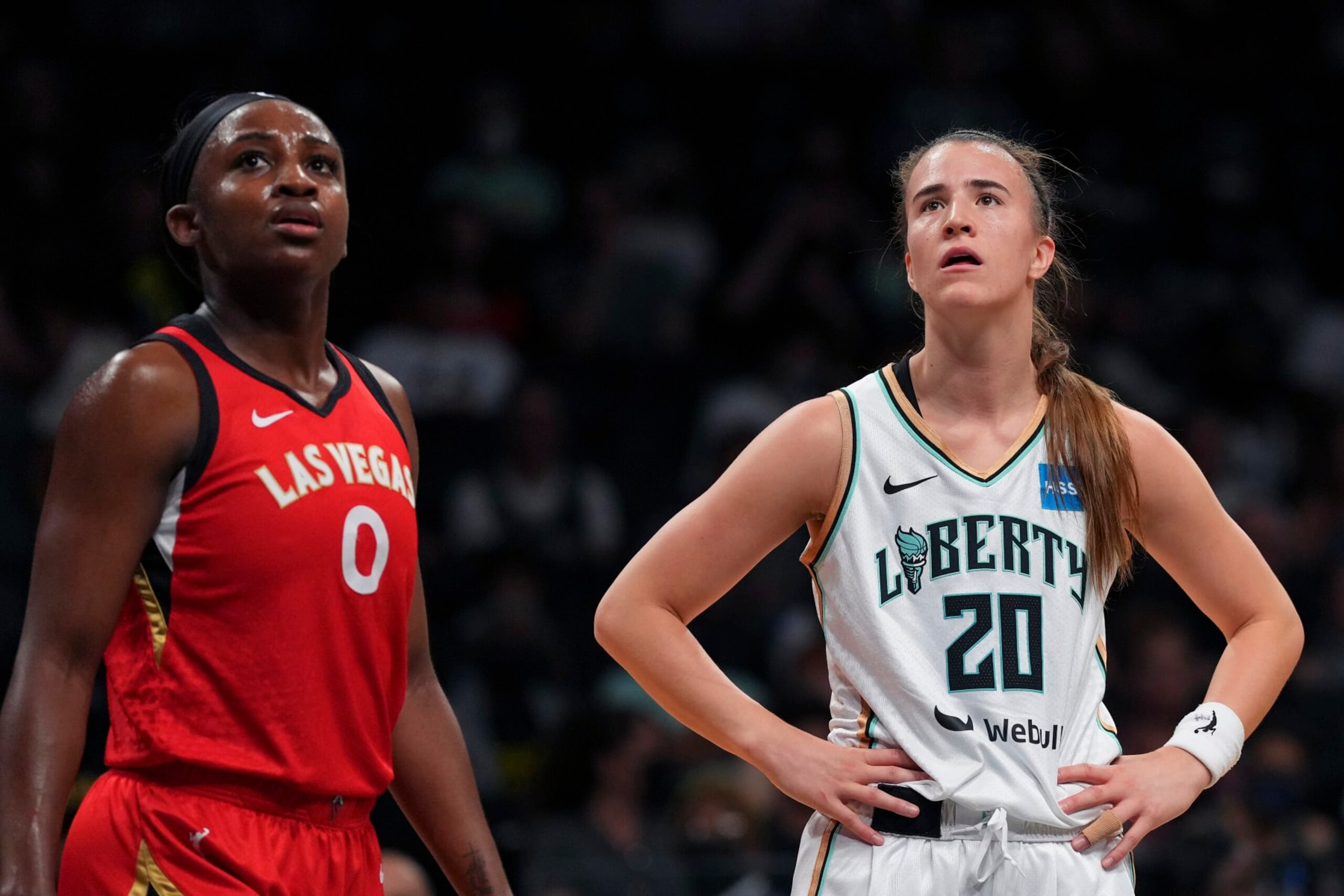 NEW YORK, NY - JULY 12: Jackie Young #0 of the Las Vegas Aces looks on along with Sabrina Ionescu #20 of the New York Liberty at Barclays Center on July 12, 2022 in the Brooklyn borough of New York City. The Las Vegas Aces defeated the New York Liberty 107-101. NOTE TO USER: User expressly acknowledges and agrees that, by downloading and/or using this Photograph, user is consenting to the terms and conditions of the Getty Images License Agreement. (Photo by Mitchell Leff/Getty Images)