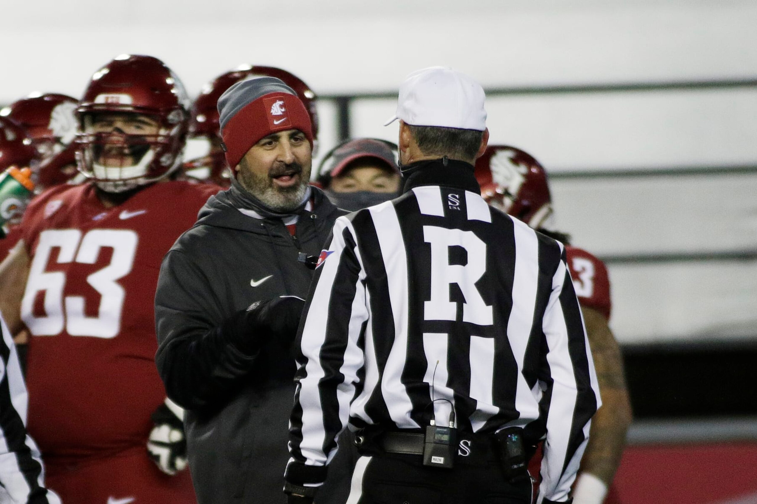 Washington State head coach Nick Rolovich, left, speaks with an official during the first half of an NCAA college football game against Oregon in Pullman, Wash., Saturday, Nov. 14, 2020. (AP Photo/Young Kwak)