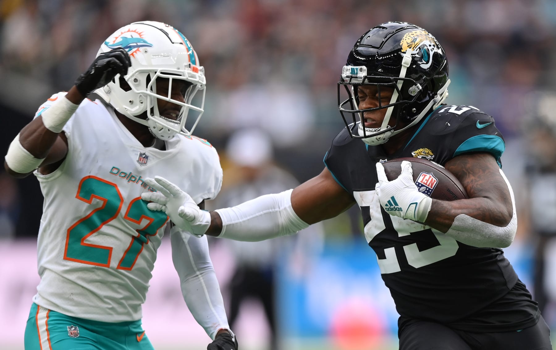 LONDON, ENGLAND - OCTOBER 17: James Robinson of the Jacksonville Jaguars holds off Justin Coleman of the Miami Dolphins during the NFL match between the Miami Dolphins and Jacksonville Jaguars at Tottenham Hotspur Stadium on October 17, 2021 in London, England. (Photo by Justin Setterfield/Getty Images)
