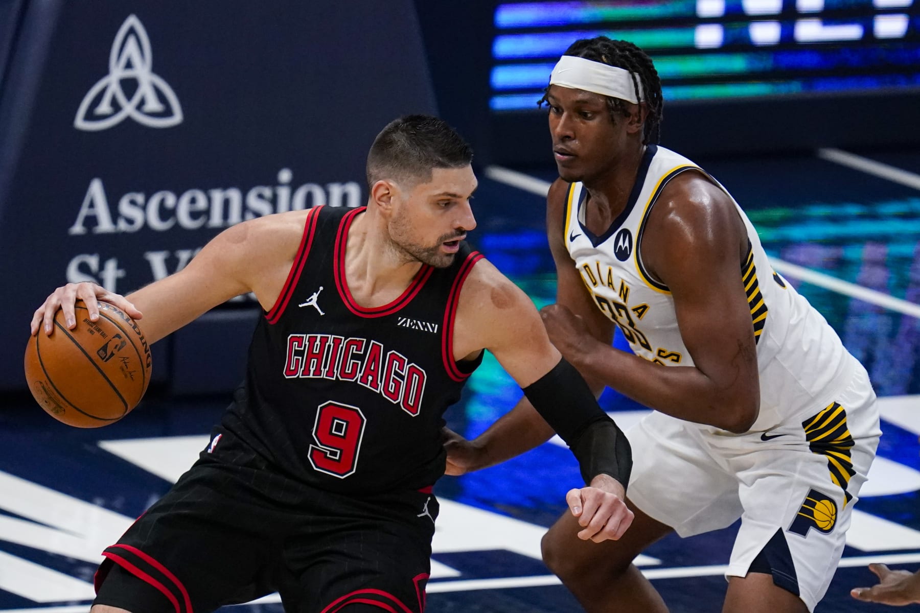 Chicago Bulls center Nikola Vucevic (9) drives on Indiana Pacers center Myles Turner (33) during the first half of an NBA basketball game in Indianapolis, Tuesday, April 6, 2021. (AP Photo/Michael Conroy)