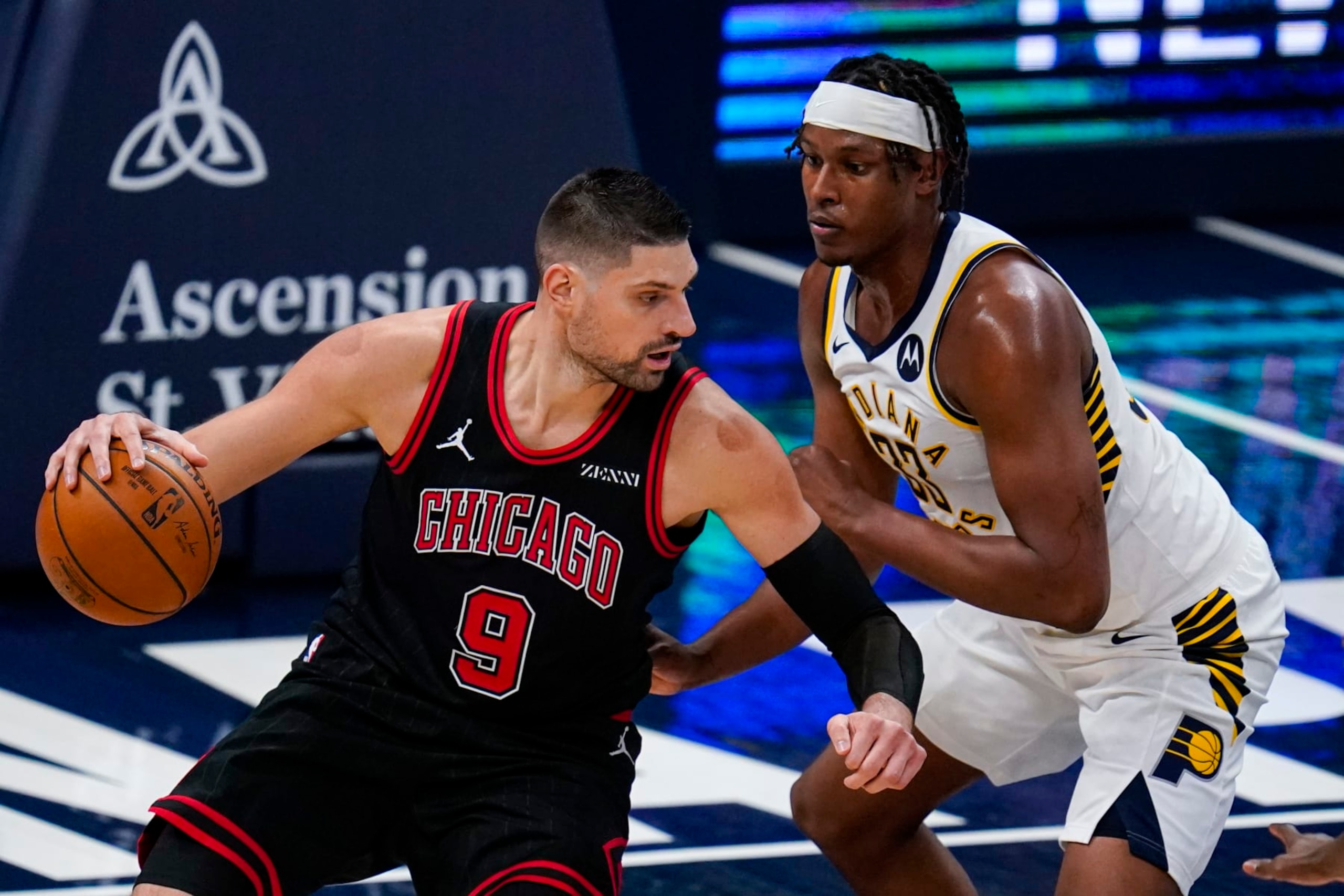 Chicago Bulls center Nikola Vucevic (9) drives on Indiana Pacers center Myles Turner (33) during the first half of an NBA basketball game in Indianapolis, Tuesday, April 6, 2021. (AP Photo/Michael Conroy)