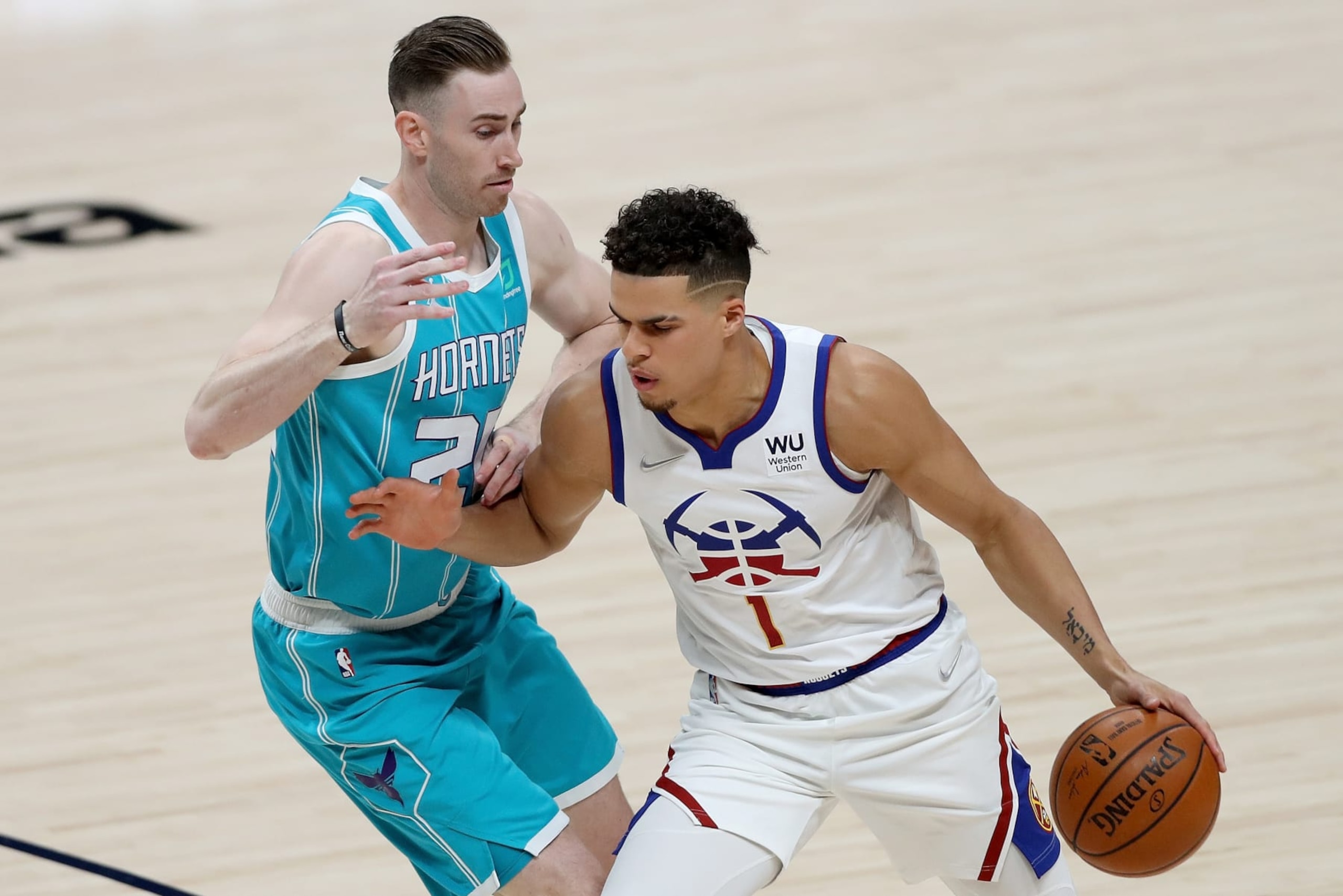 DENVER, COLORADO - MARCH 17: Michael Porter Jr. #1 of the Denver Nuggets is guarded by Gordon Hayward #20 of the Charlotte Hornets in the first quarter at Ball Arena on March 17, 2021 in Denver, Colorado. NOTE TO USER: User expressly acknowledges and agrees that, by downloading and or using this photograph, User is consenting to the terms and conditions of the Getty Images License Agreement. (Photo by Matthew Stockman/Getty Images)