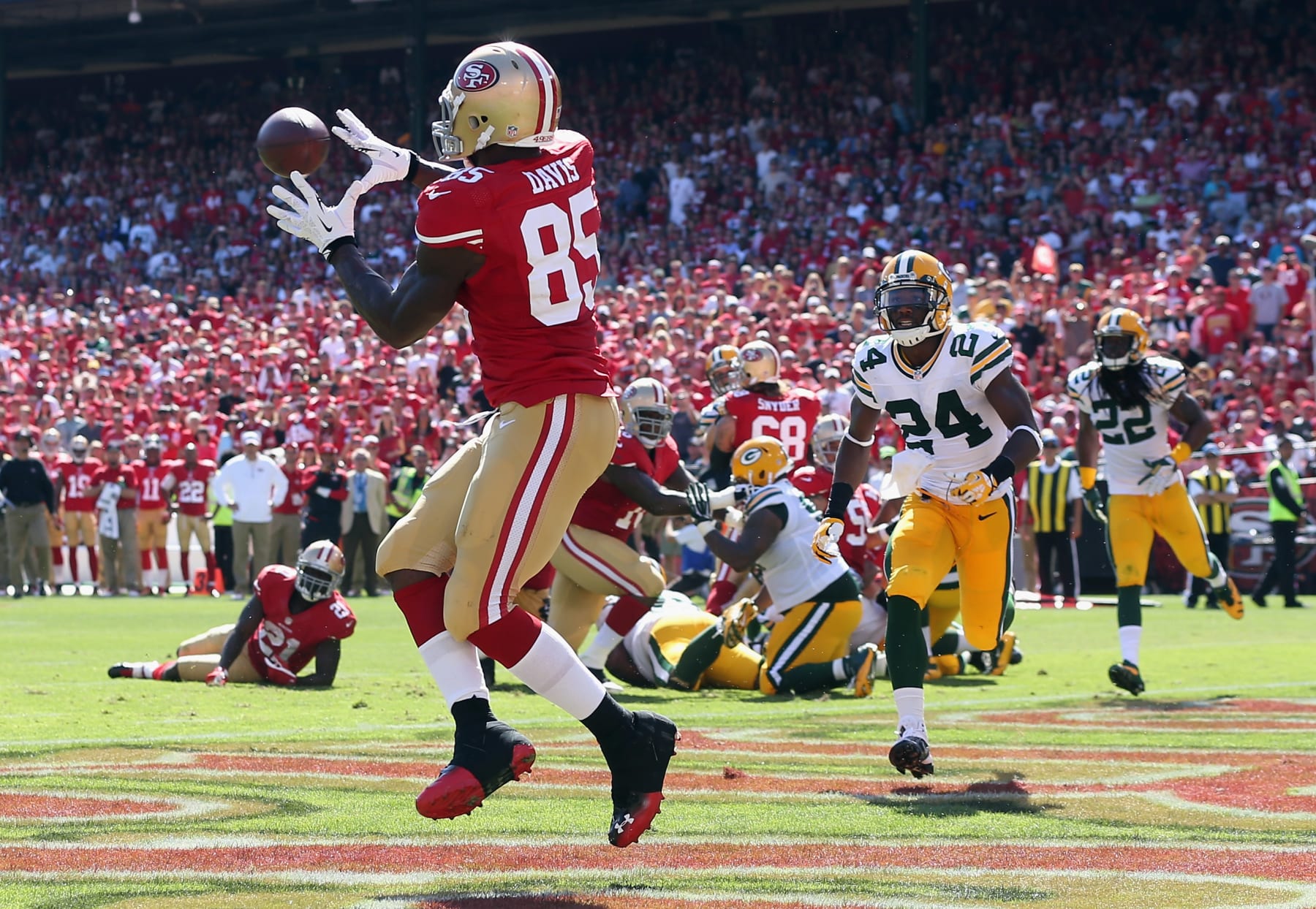 SAN FRANCISCO, CA - SEPTEMBER 08:  Tight end Vernon Davis #85 of the San Francisco 49ers catches a pass for a touchdown, as Jarrett Bush #24 of the Green Bay Packers pursues in the third quarter at Candlestick Park on September 8, 2013 in San Francisco, California. The 49ers defeated the Packers 34-28.  (Photo by Jeff Gross/Getty Images)
