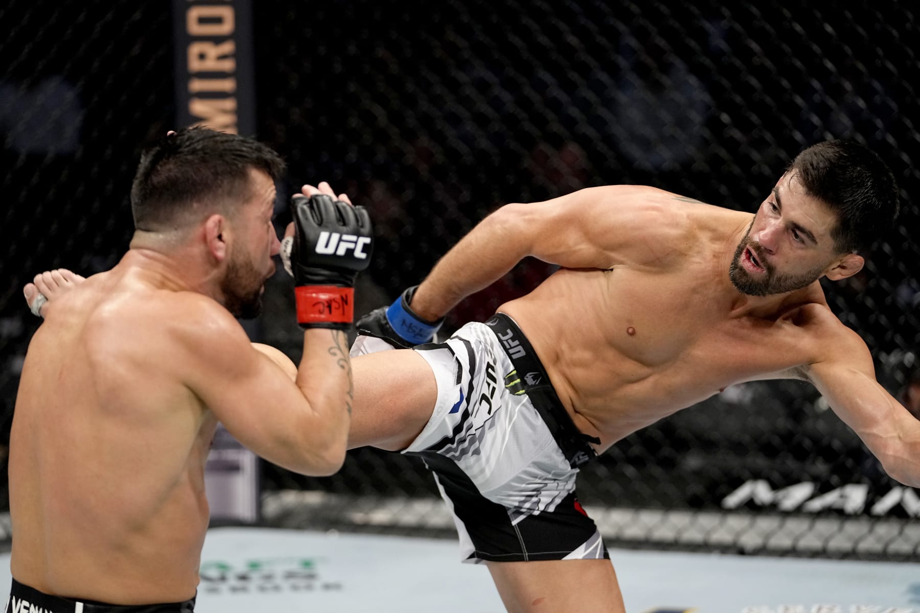 LAS VEGAS, NEVADA - DECEMBER 11: Dominick Cruz kicks Pedro Munhoz of Brazil in their bantamweight bout during the UFC 269 on December 11, 2021 in Las Vegas, Nevada. (Photo by Jeff Bottari/Zuffa LLC)