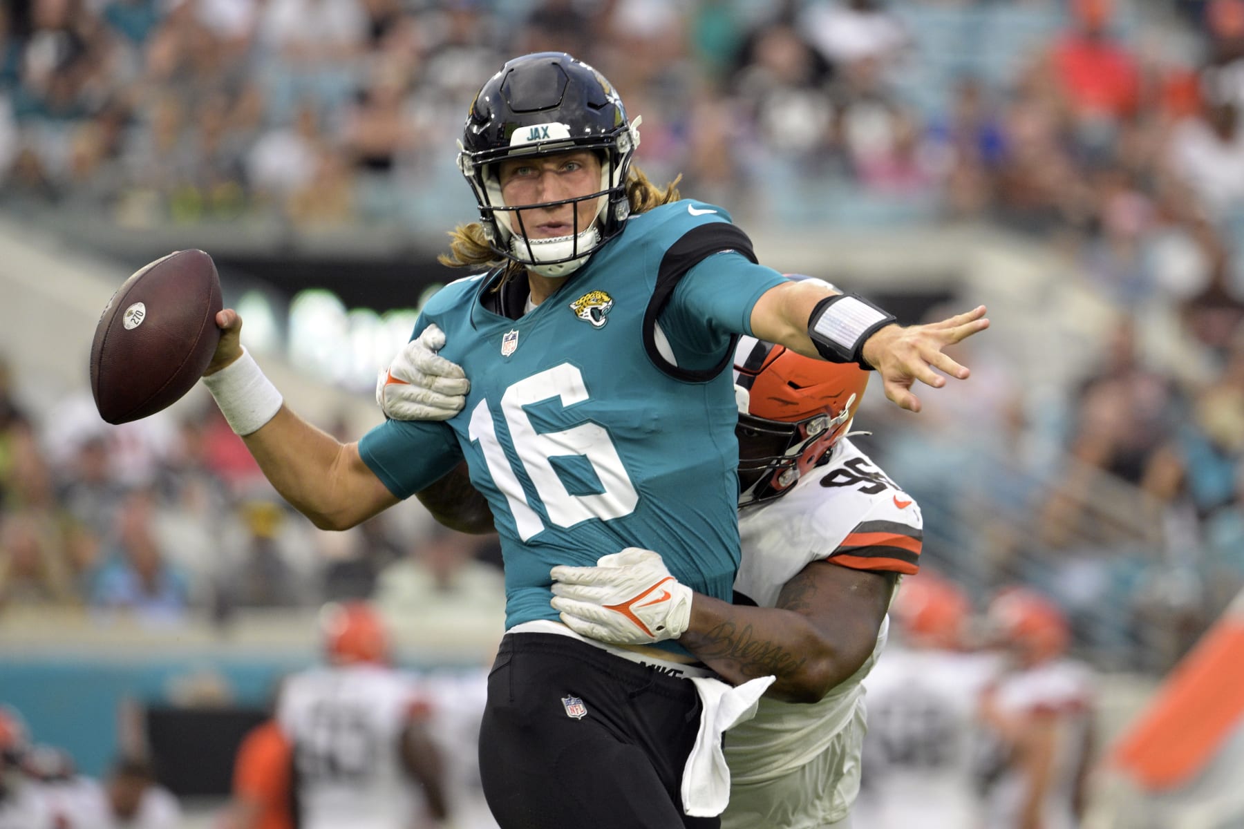 Jacksonville Jaguars quarterback Trevor Lawrence (16) throws a pass has he is hit by Cleveland Browns defensive tackle Jordan Elliott (96) during the first half of an NFL preseason football game, Friday, Aug. 12, 2022, in Jacksonville, Fla. (AP Photo/Phelan M. Ebenhack)