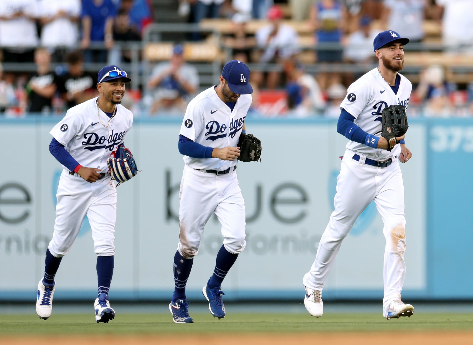 LOS ANGELES, CALIFORNIA - AUGUST 07: (R-L) Cody Bellinger #35, Chris Taylor #3 and Mookie Betts #50 of the Los Angeles Dodgers react as they leave the field after a 4-0 win over the San Diego Padres at Dodger Stadium on August 07, 2022 in Los Angeles, California. (Photo by Harry How/Getty Images)