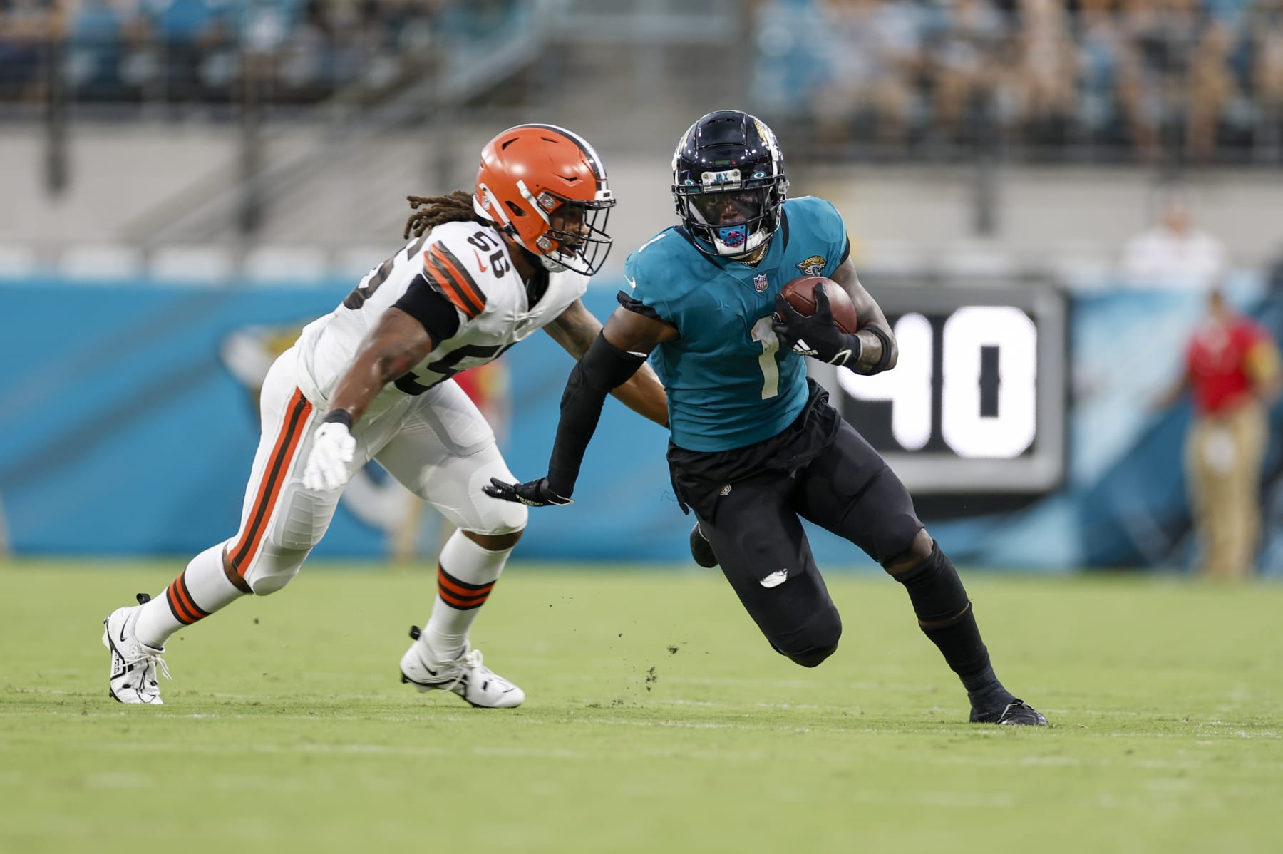 JACKSONVILLE, FL - AUGUST 12: Jacksonville Jaguars running back Travis Etienne Jr. (1) runs with the ball past Cleveland Browns linebacker Dakota Allen (56) during the game between the Cleveland Browns and the Jacksonville Jaguars on August 12, 2022 at TIAA Bank Field in Jacksonville, Fl. (Photo by David Rosenblum/Icon Sportswire via Getty Images)