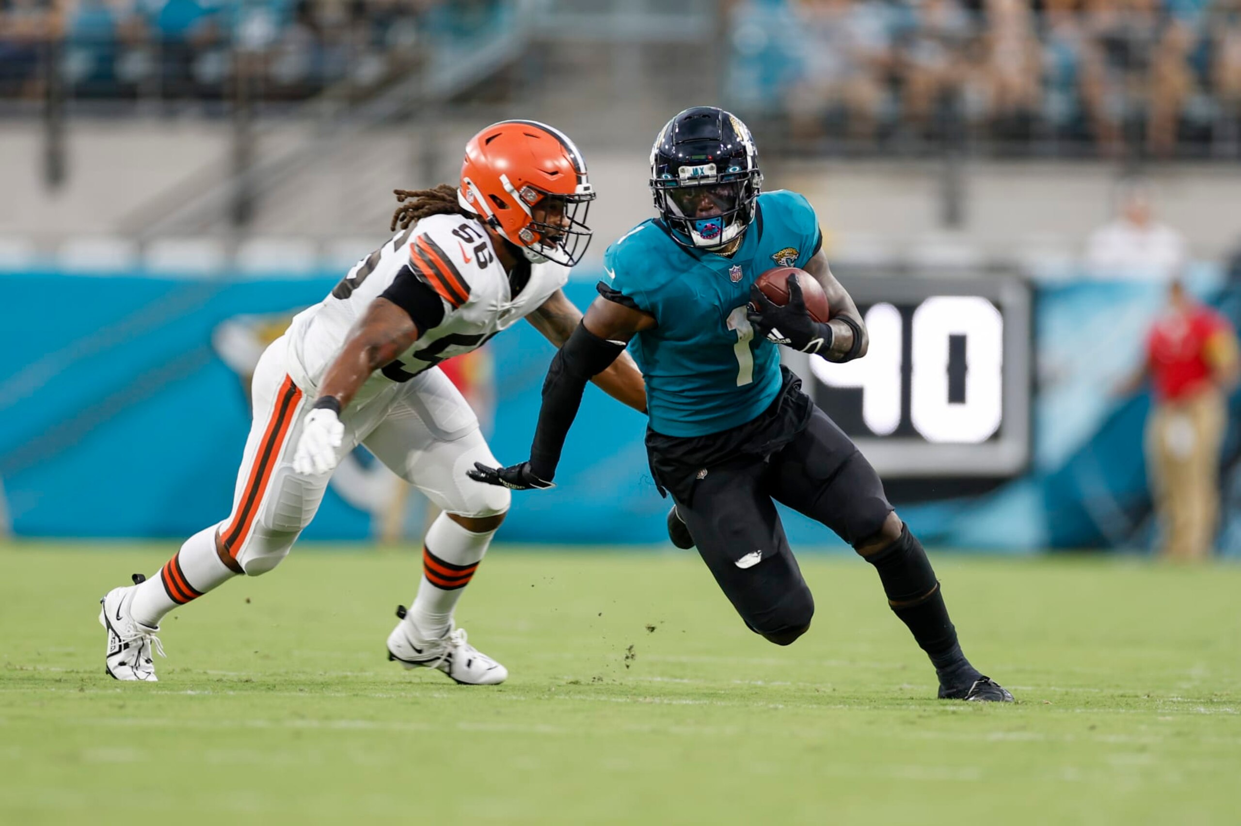 JACKSONVILLE, FL - AUGUST 12: Jacksonville Jaguars running back Travis Etienne Jr. (1) runs with the ball past Cleveland Browns linebacker Dakota Allen (56) during the game between the Cleveland Browns and the Jacksonville Jaguars on August 12, 2022 at TIAA Bank Field in Jacksonville, Fl. (Photo by David Rosenblum/Icon Sportswire via Getty Images)