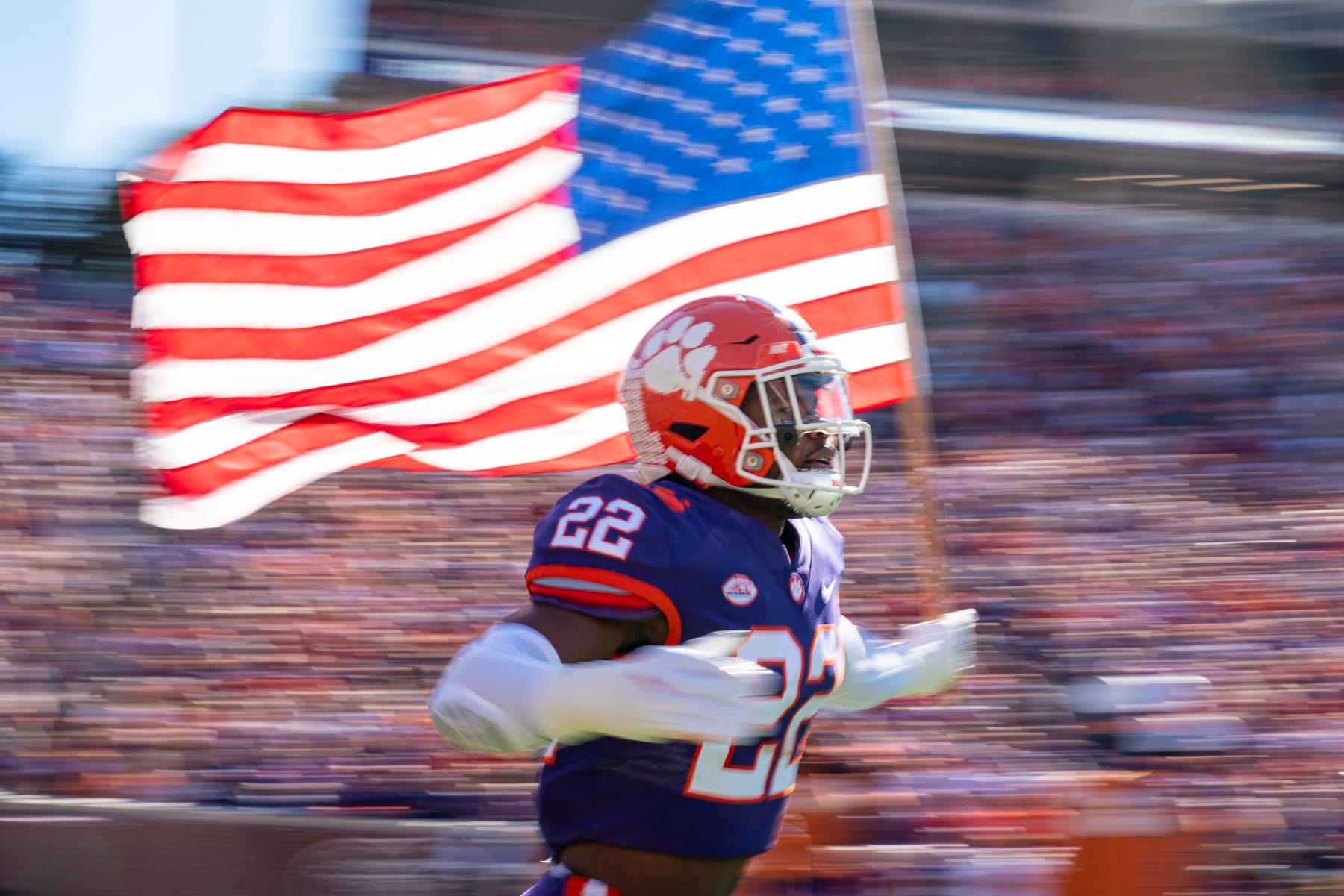 CLEMSON, SOUTH CAROLINA - NOVEMBER 13: Linebacker Trenton Simpson #22 of the Clemson Tigers runs onto the field carrying an American flag at the start of their game against the Connecticut Huskies at Clemson Memorial Stadium on November 13, 2021 in Clemson, South Carolina. (Photo by Jacob Kupferman/Getty Images)