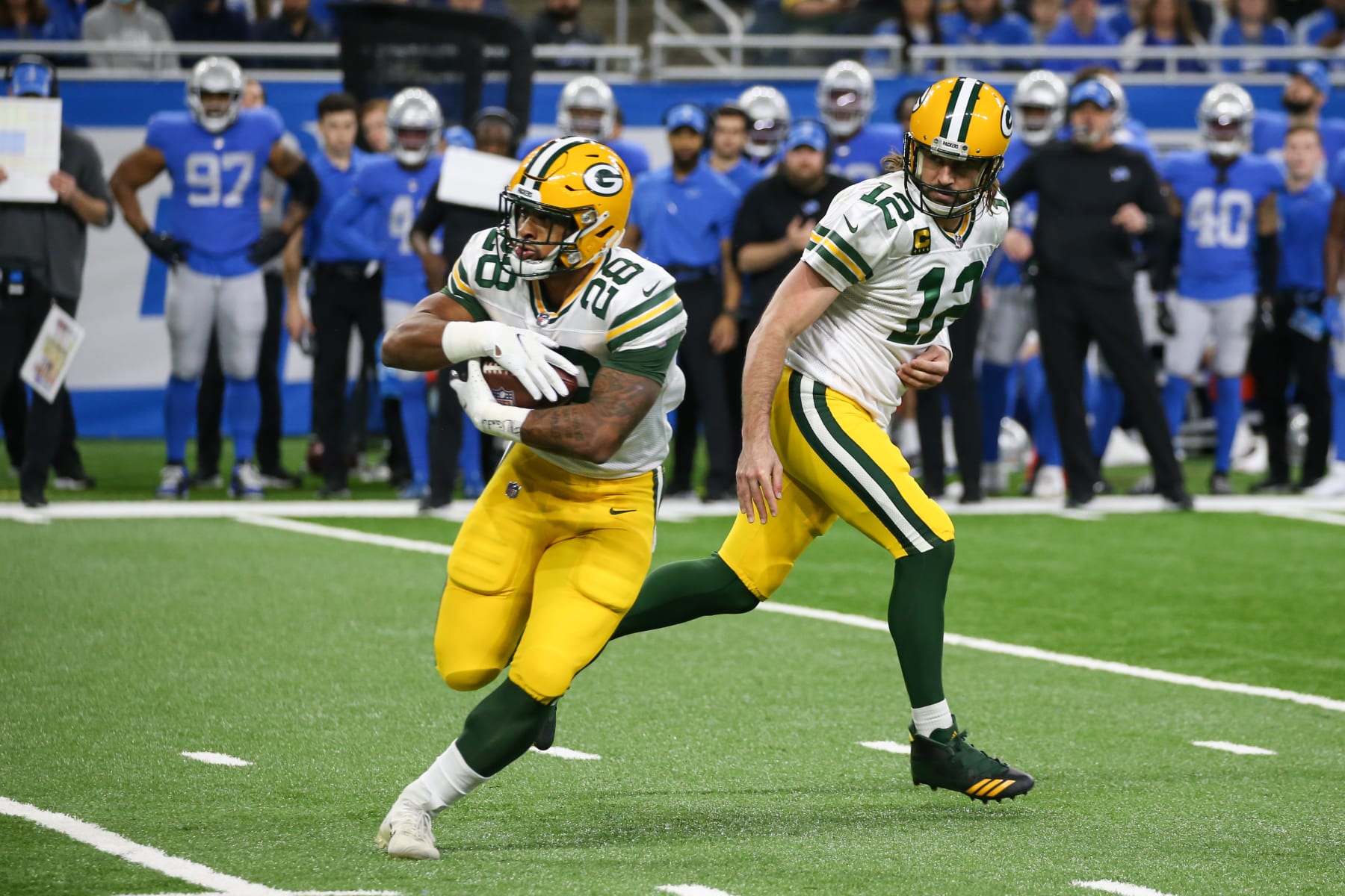 DETROIT, MI - JANUARY 09:  Green Bay Packers running back AJ Dillon (28) takes a handoff from Green Bay Packers quarterback Aaron Rodgers (12) during a regular season NFL game between the Green Bay Packers and the Detroit Lions on January 9, 2022 at Ford Field in Detroit, Michigan.  (Photo by Scott W. Grau/Icon Sportswire via Getty Images)