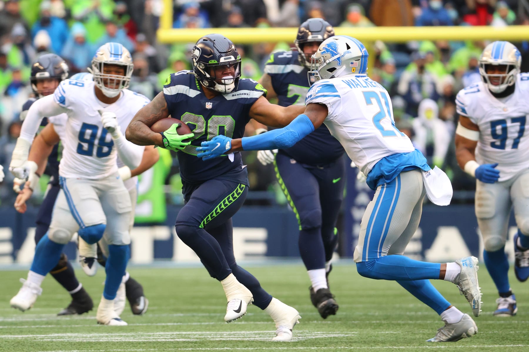 SEATTLE, WASHINGTON - JANUARY 02: Rashaad Penny #20 of the Seattle Seahawks carries the ball against Tracy Walker III #21 of the Detroit Lions during the first quarter at Lumen Field on January 02, 2022 in Seattle, Washington. (Photo by Abbie Parr/Getty Images)