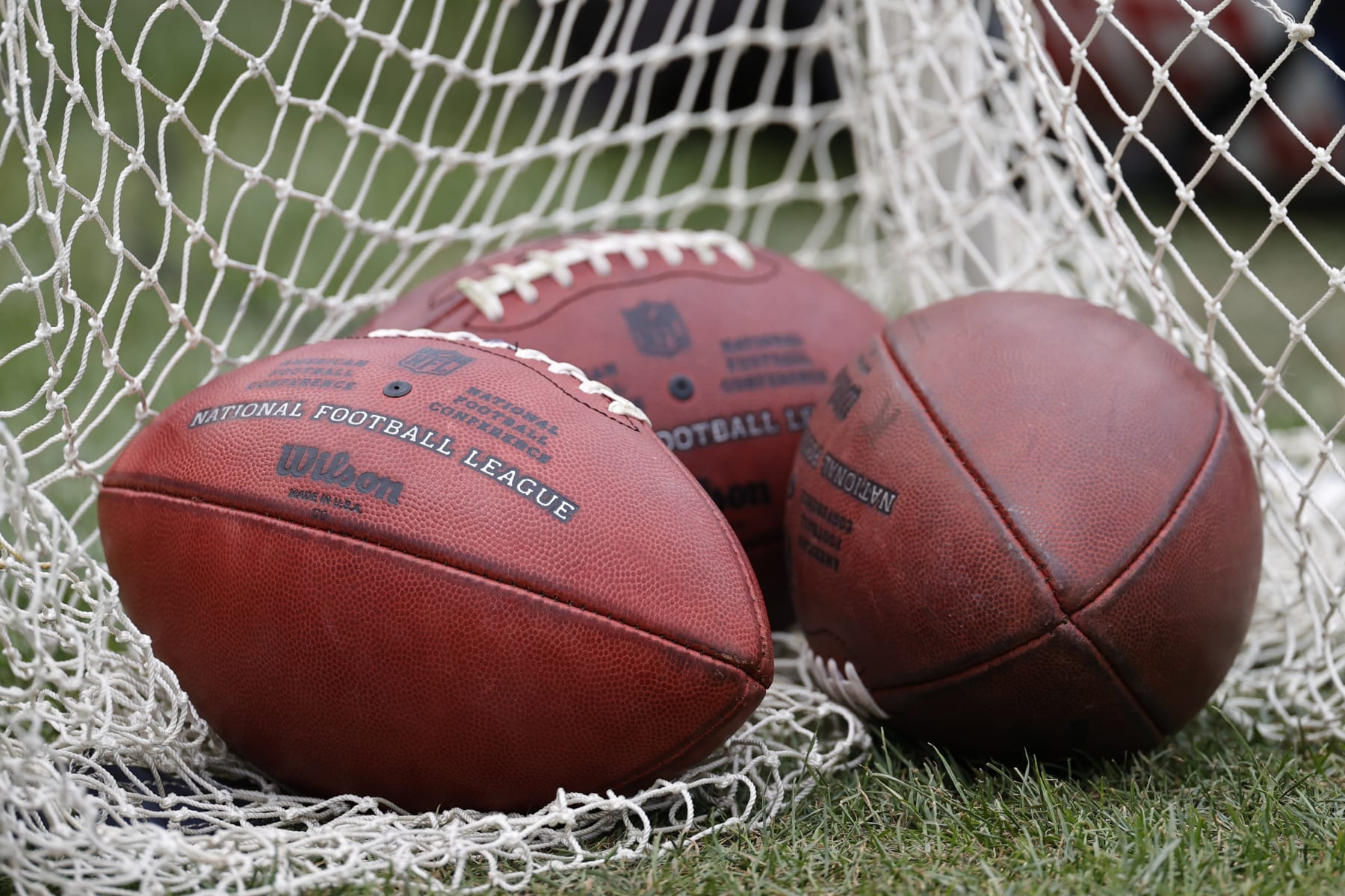 Wilson footballs sit on the sidelines during the first half of a preseason NFL football game between the Chicago Bears and Kansas City Chiefs, Saturday, Aug. 13, 2022, in Chicago. (AP Photo/Kamil Krzaczynski)