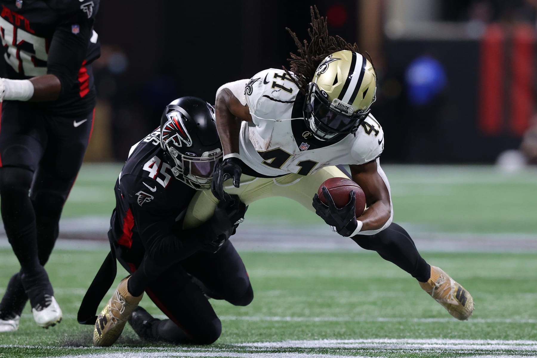 ATLANTA, GEORGIA - JANUARY 09: Alvin Kamara #41 of the New Orleans Saints is tackled by Deion Jones #45 of the Atlanta Falcons during the second quarter at Mercedes-Benz Stadium on January 09, 2022 in Atlanta, Georgia. (Photo by Todd Kirkland/Getty Images) ATLANTA, GEORGIA - JANUARY 09: Alvin Kamara #41 of the New Orleans Saints is tackled by Deion Jones #45 of the Atlanta Falcons during the second quarter at Mercedes-Benz Stadium on January 09, 2022 in Atlanta, Georgia. (Photo by Todd Kirkland/Getty Images)