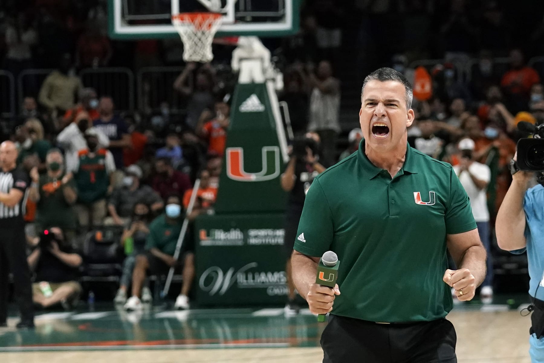 Miami head football coach Mario Cristobal encourages the crowd during the second half of an NCAA college basketball game between Miami and Florida State, Saturday, Jan. 22, 2022, in Coral Gables, Fla. Florida State won 61-60. (AP Photo/Lynne Sladky)