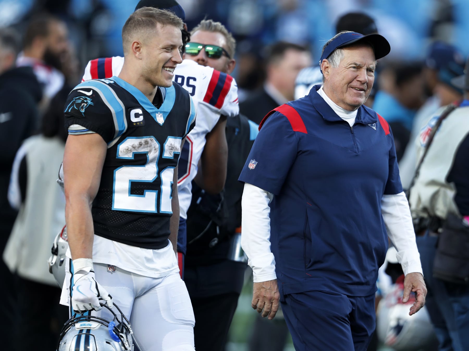 Charlotte, NC - November 7: New England Patriots head coach Bill Belichick (right) flashes a grin after he said something to Panthers running back Christian McCaffrey (left) as they chatted on the field after the game. The New England Patriots visited the Carolina Panthers for a regular season NFL football game at Bank of America Stadium in Charlotte, NC on Nov. 7, 2021. (Photo by Jim Davis/The Boston Globe via Getty Images)
