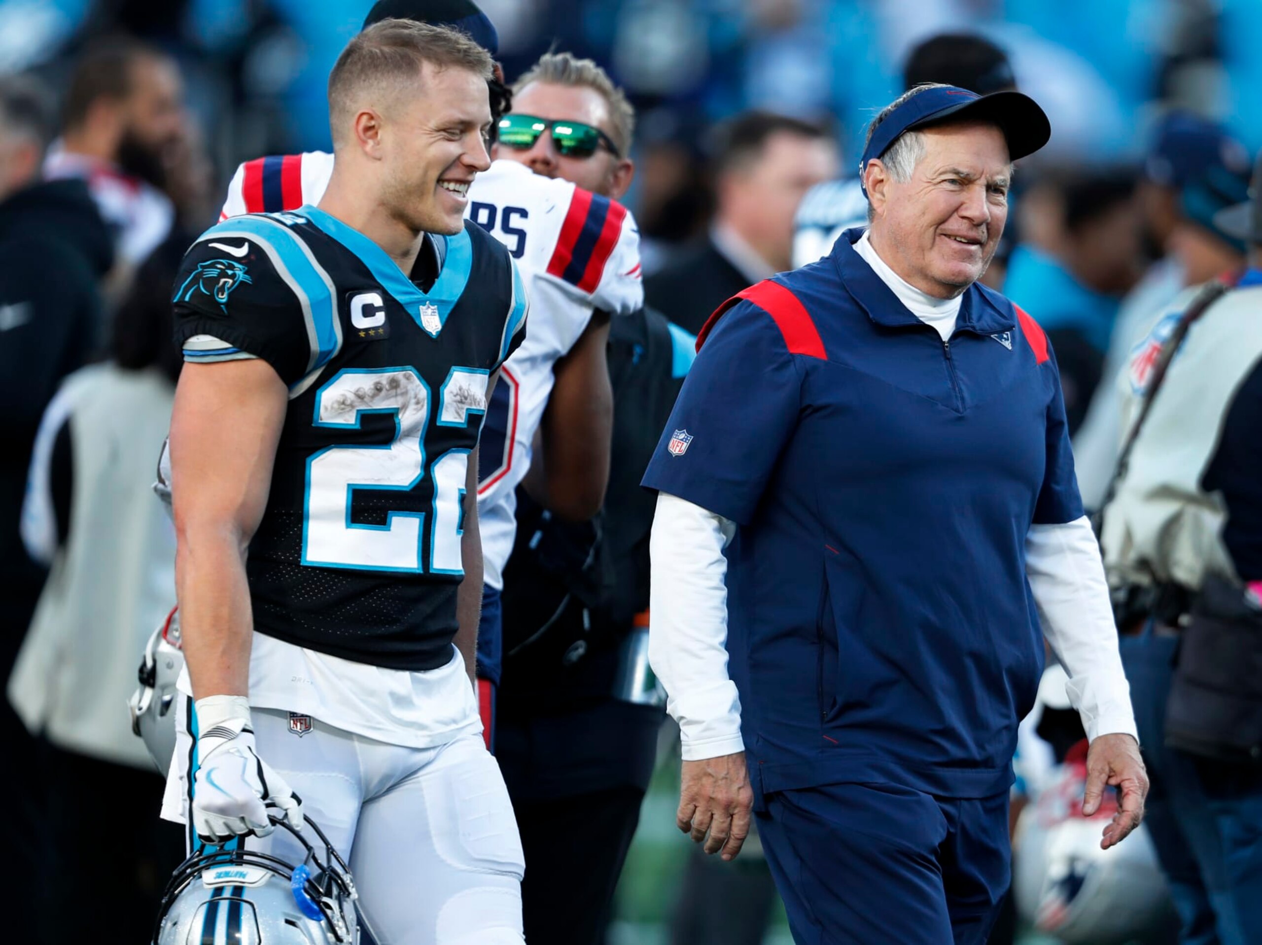 Charlotte, NC - November 7: New England Patriots head coach Bill Belichick (right) flashes a grin after he said something to Panthers running back Christian McCaffrey (left) as they chatted on the field after the game. The New England Patriots visited the Carolina Panthers for a regular season NFL football game at Bank of America Stadium in Charlotte, NC on Nov. 7, 2021. (Photo by Jim Davis/The Boston Globe via Getty Images)