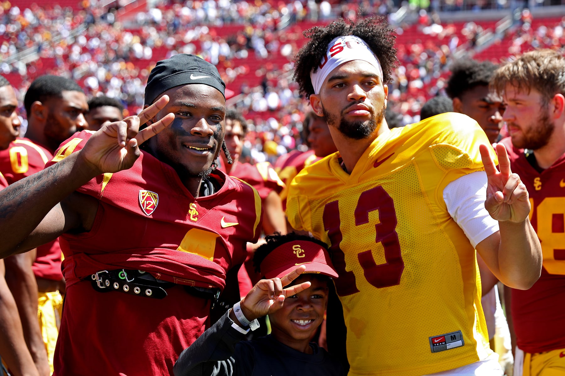 LOS ANGELES, CA - APRIL 23: USC wide receiver Mario Williams (4) and USC quarterback Caleb Williams (13) pose for a photograph with a fan at the conclusion of the USC Football Spring Game at the Los Angeles Memorial Coliseum on Saturday, April 23, 2022 in Los Angeles, CA. (Gary Coronado / Los Angeles Times via Getty Images)