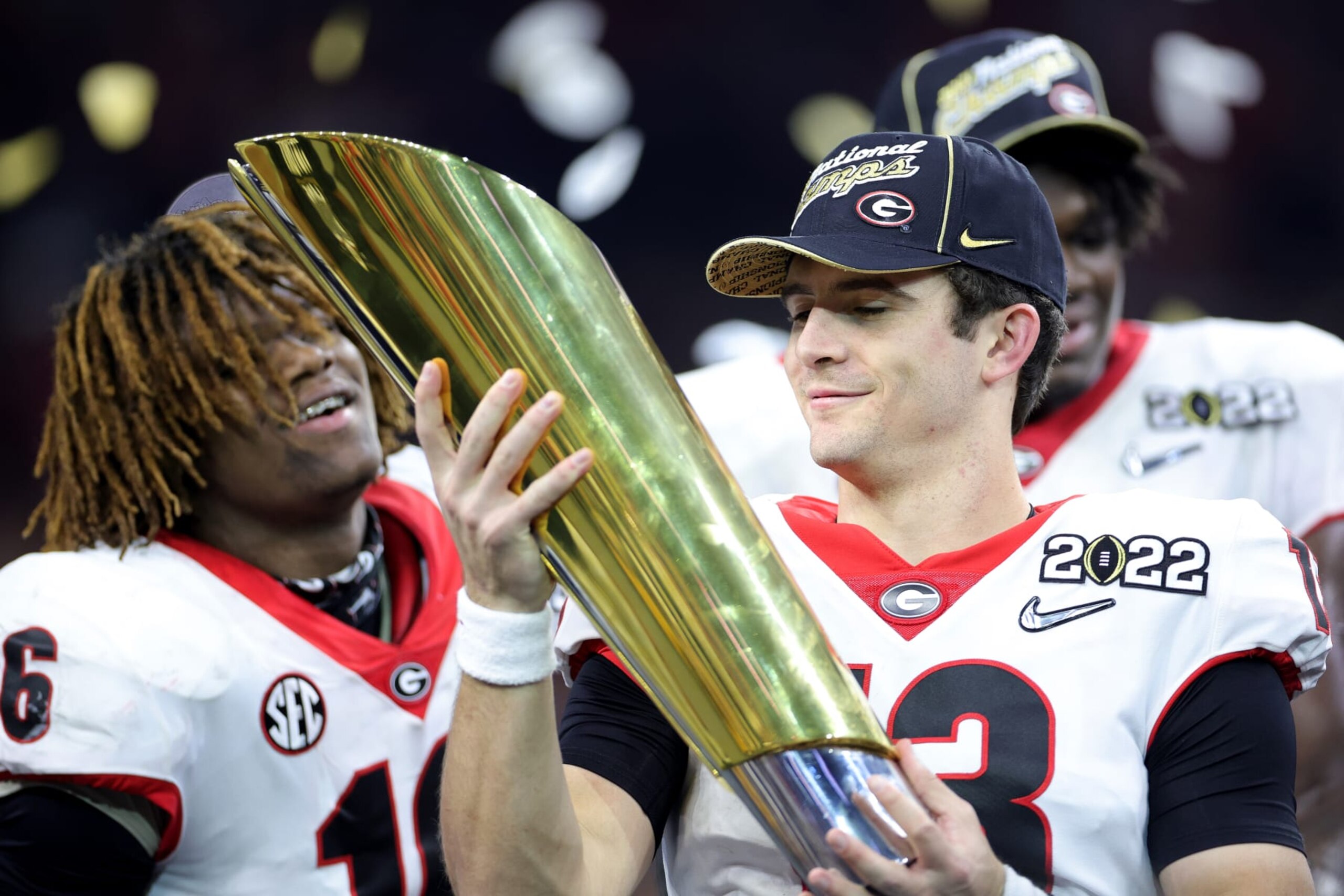 INDIANAPOLIS, INDIANA - JANUARY 10: Stetson Bennett #13 of the Georgia Bulldogs celebrates with the National Championship trophy after the Georgia Bulldogs defeated the Alabama Crimson Tide 33-18 during the 2022 CFP National Championship Game at Lucas Oil Stadium on January 10, 2022 in Indianapolis, Indiana. (Photo by Carmen Mandato/Getty Images)