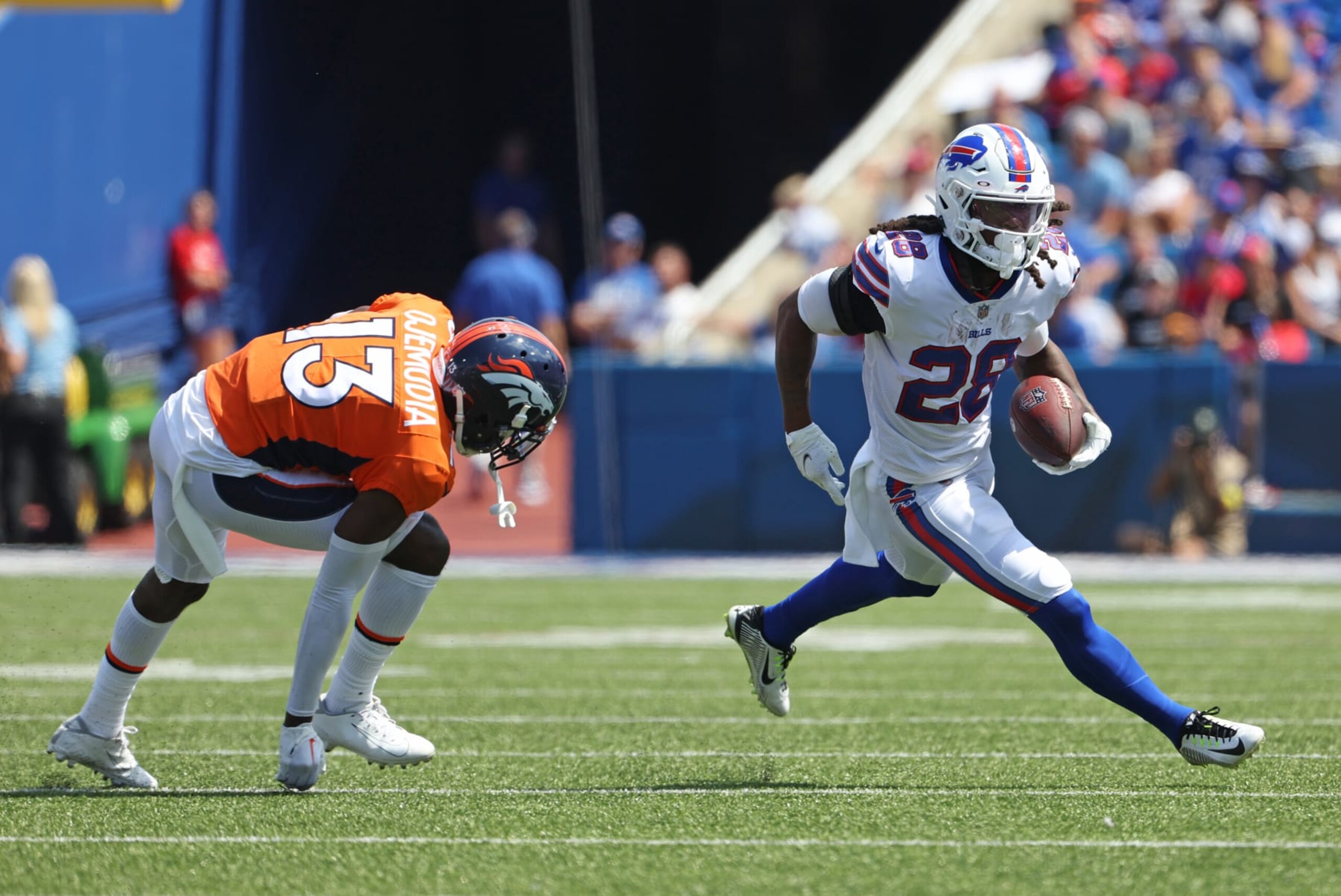 ORCHARD PARK, NY - AUGUST 20: James Cook #28 of the Buffalo Bills runs the ball asMichael Ojemudia #13 of the Denver Broncos looks to defend during the first half of a preseason game at Highmark Stadium on August 20, 2022 in Orchard Park, New York. (Photo by Timothy T Ludwig/Getty Images)