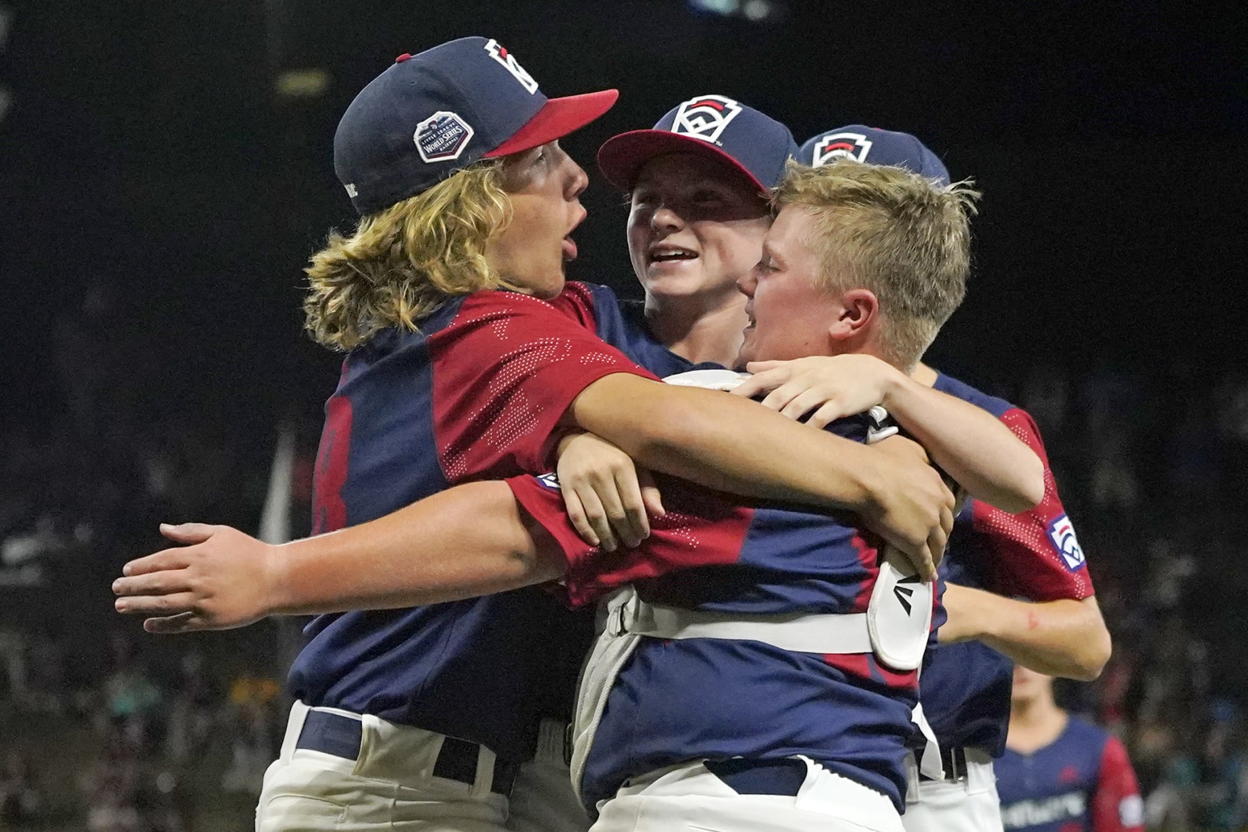 Hollidaysburg, Pa.'s Chase Link, left, Aspen Anderson, center, and catcher Braden Hatch celebrate after getting the final out of a baseball game against Middleborough, Mass., at the Little League World Series in South Williamsport, Pa., Saturday, Aug. 20, 2022. (AP Photo/Gene J. Puskar)