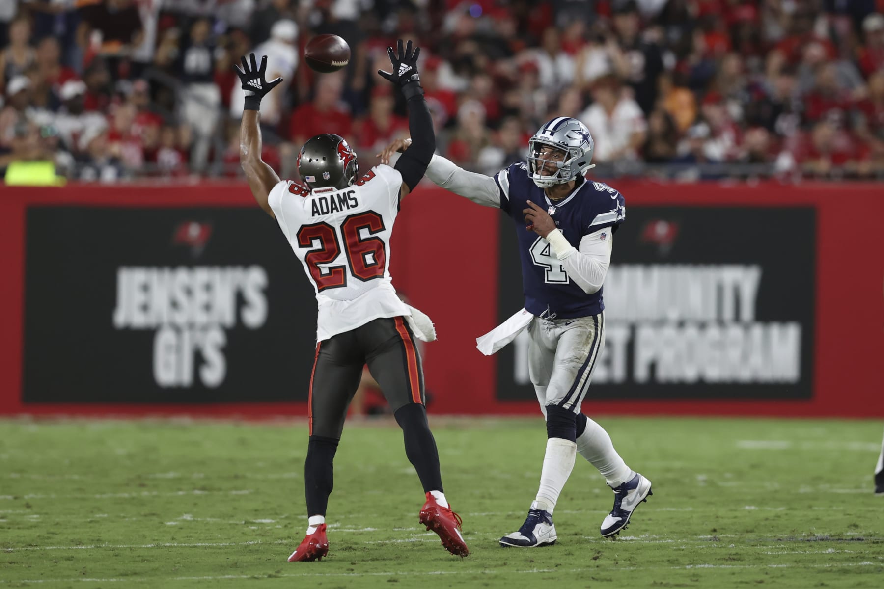 Dallas Cowboys quarterback Dak Prescott (4) passes over Tampa Bay Buccaneers safety Andrew Adams (26) during the second half of an NFL football game Thursday, Sept. 9, 2021, in Tampa, Fla. (AP Photo/Mark LoMoglio)