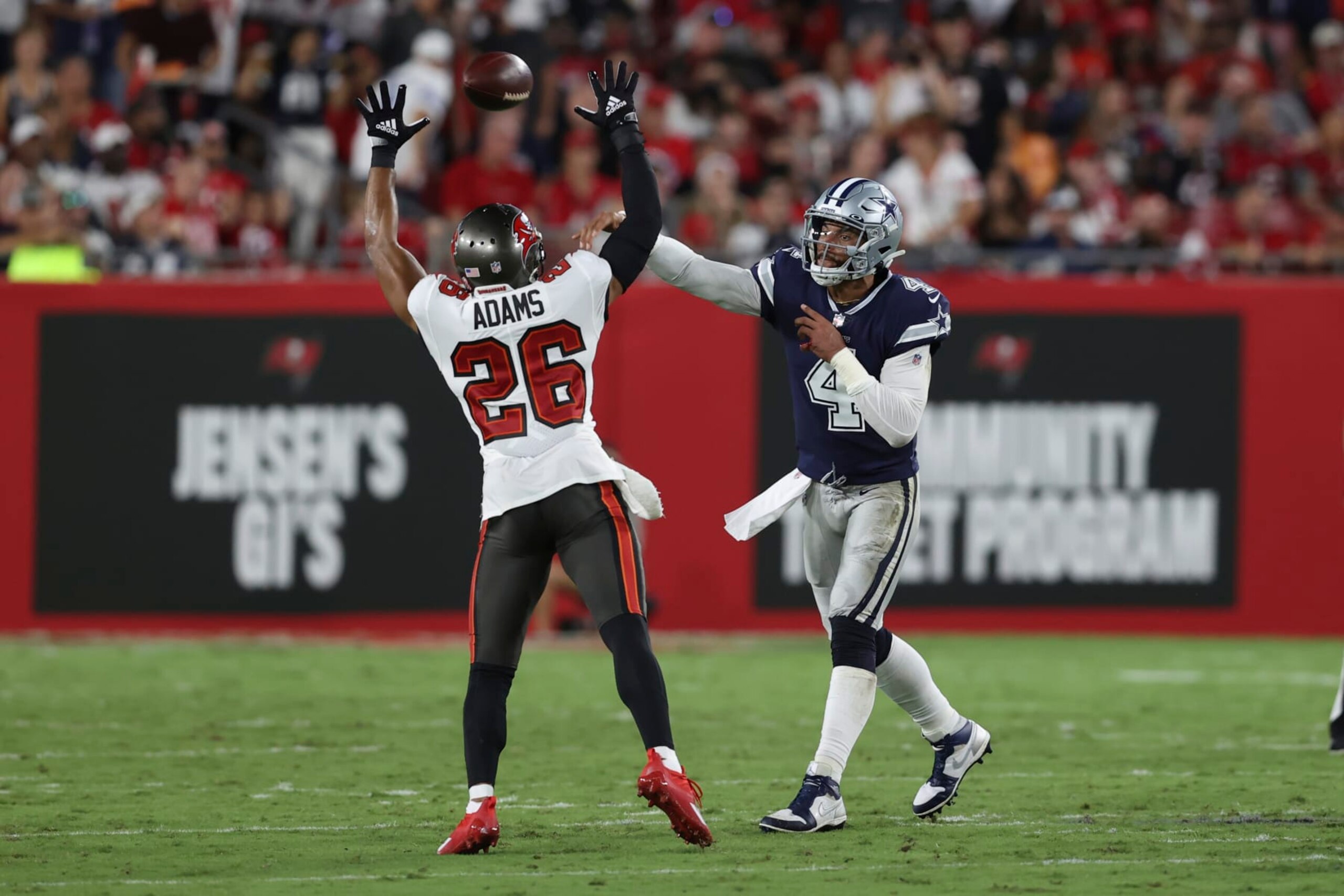 Dallas Cowboys quarterback Dak Prescott (4) passes over Tampa Bay Buccaneers safety Andrew Adams (26) during the second half of an NFL football game Thursday, Sept. 9, 2021, in Tampa, Fla. (AP Photo/Mark LoMoglio)